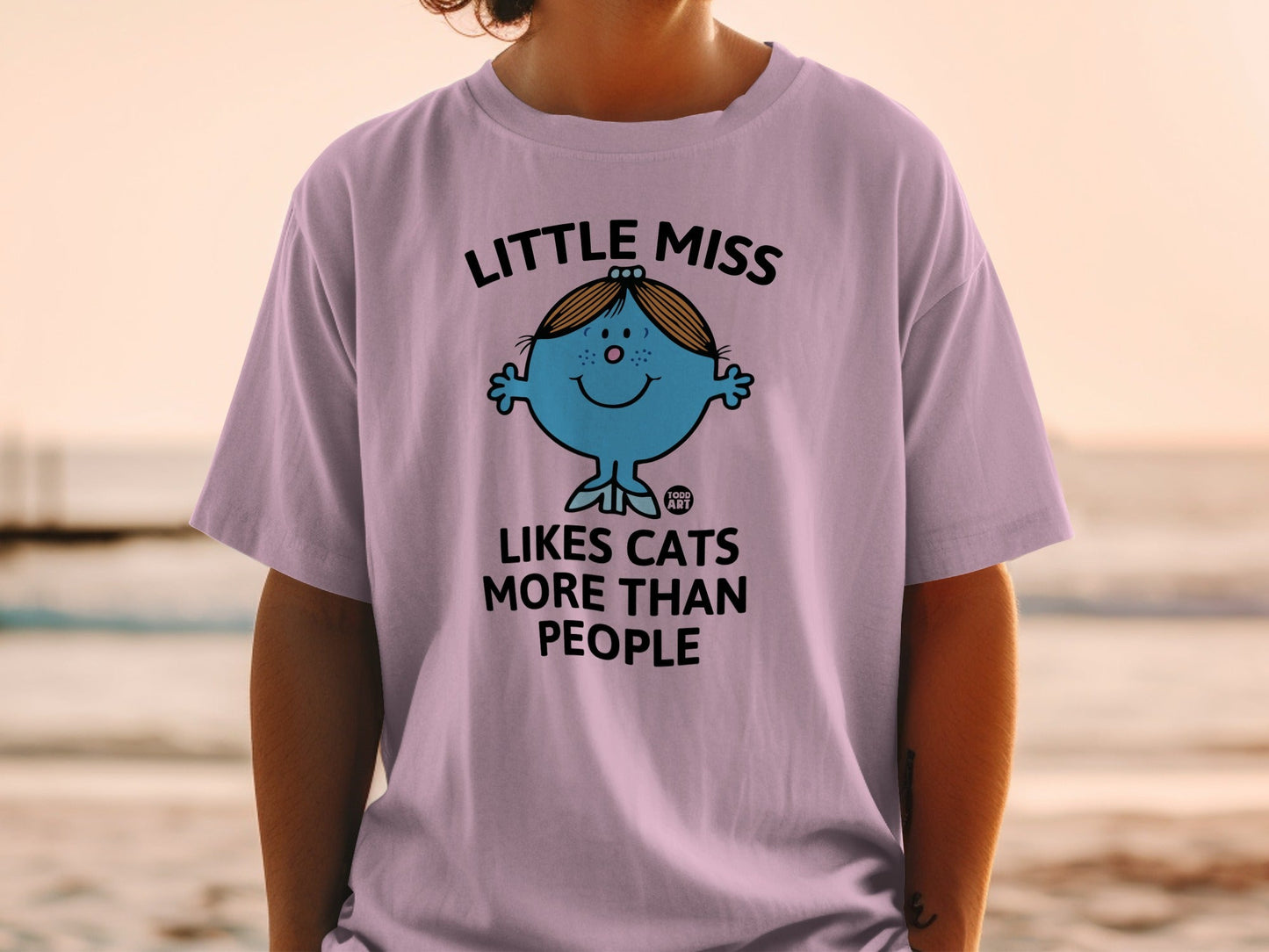 Lilac t-shirt with "Little Miss Likes Cats More Than People" text and cartoon character.