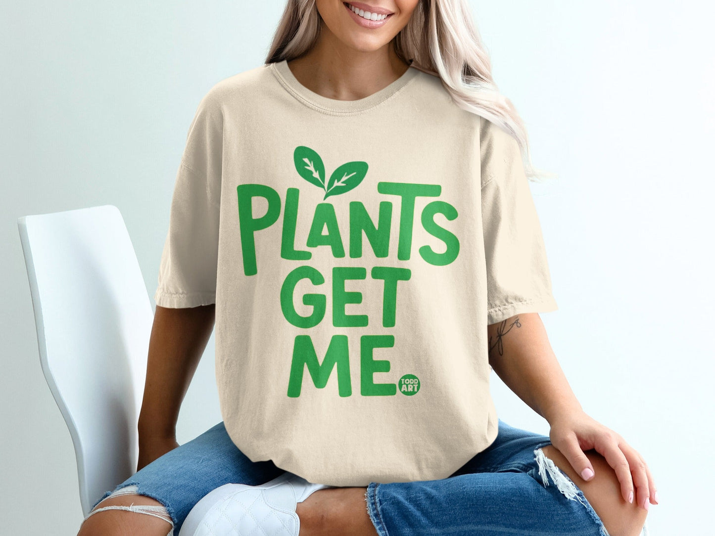 Cream t-shirt with green text "PLANTS GET ME" and small leaf graphic.