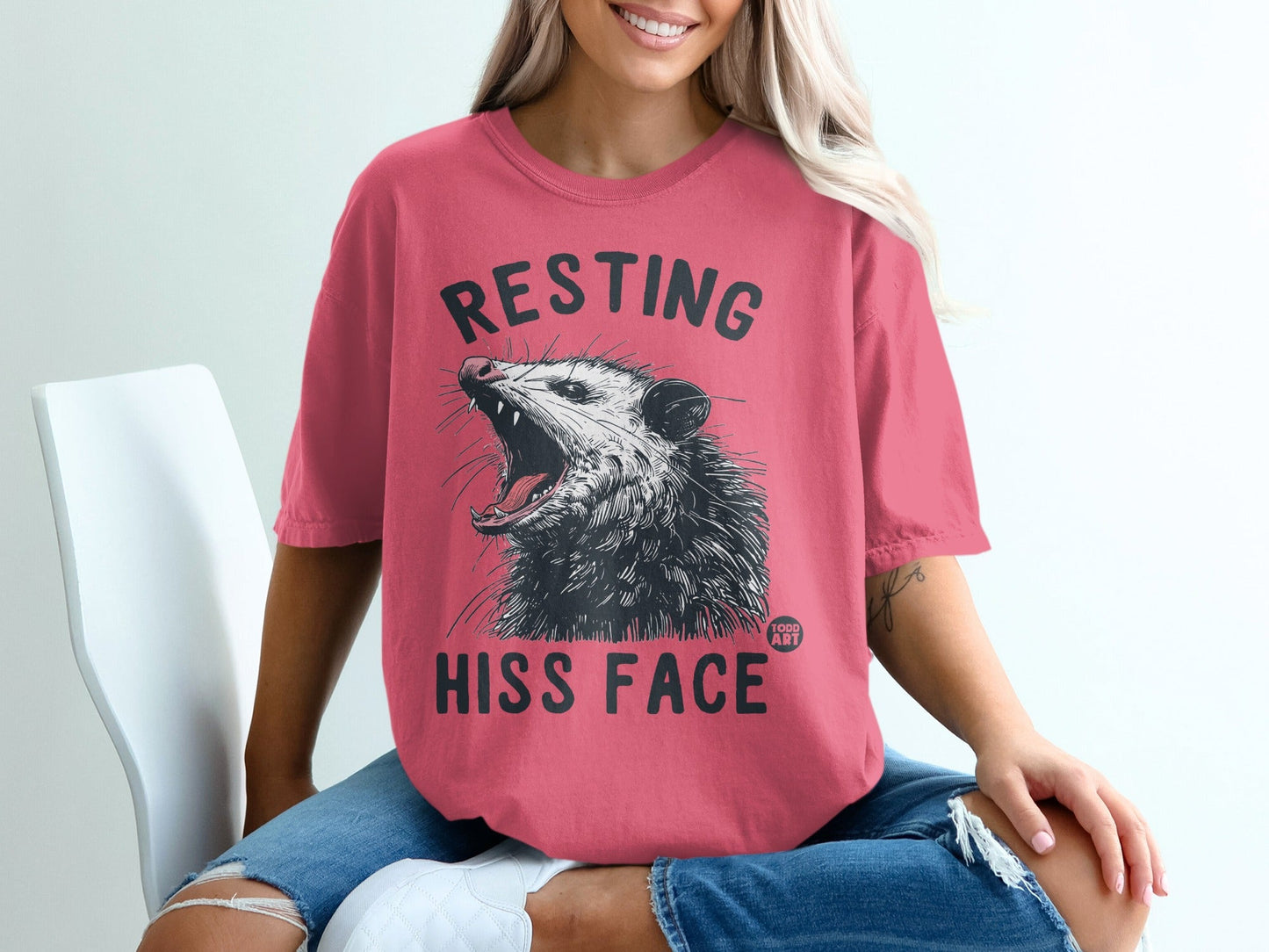 Pink t-shirt with "RESTING HISS FACE" and a possum graphic.