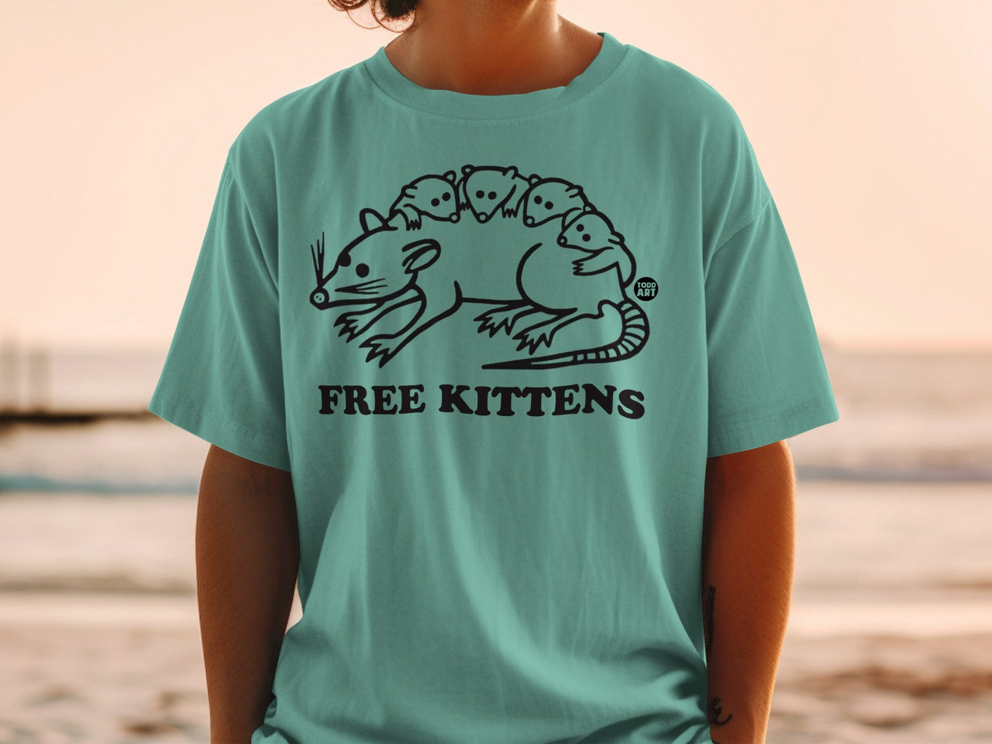 T-shirt with line drawing of a rat carrying several baby rats, text "FREE KITTENS".