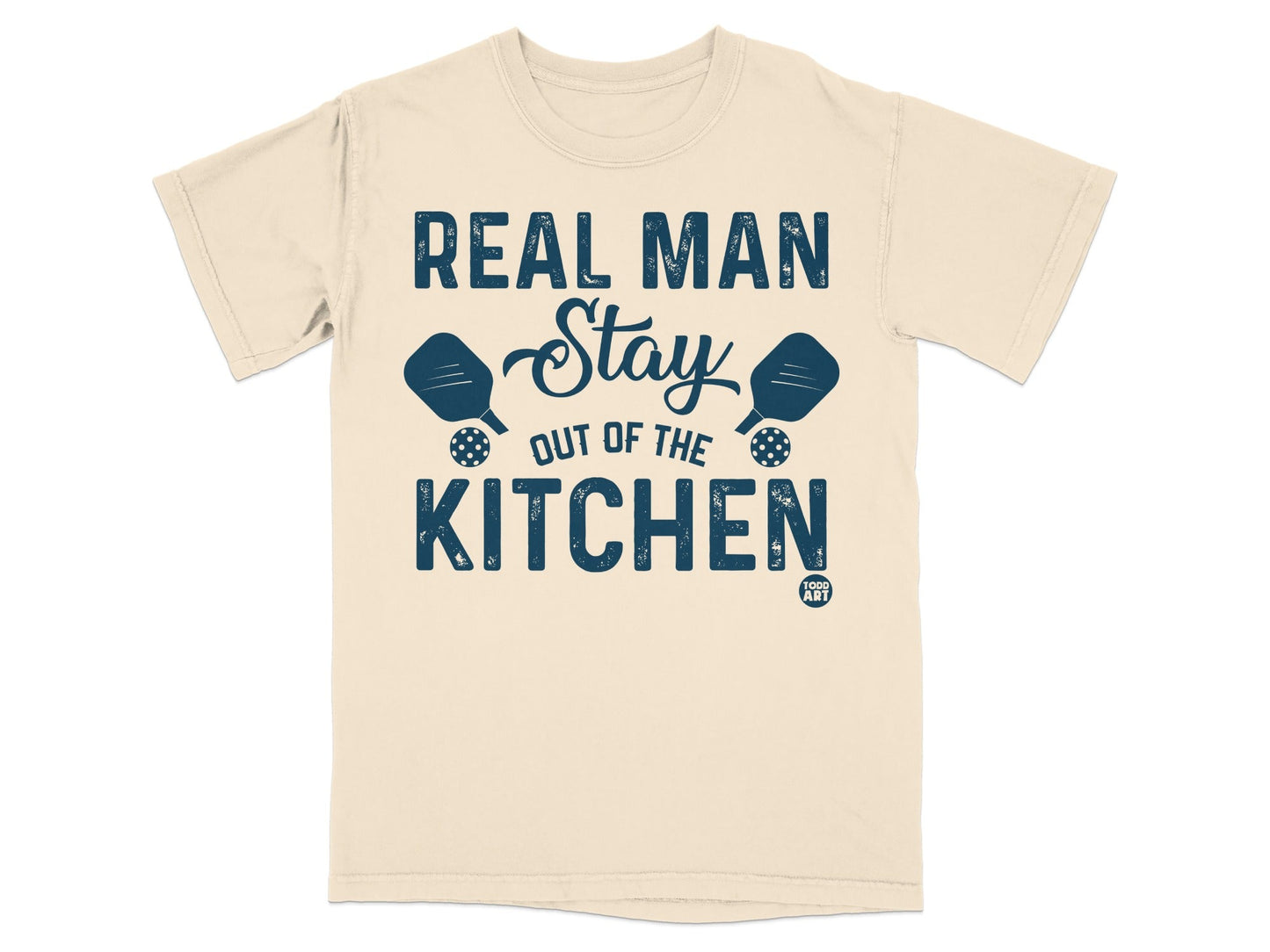 Beige t-shirt with "REAL MAN Stay OUT OF THE KITCHEN" and pickleball paddles.