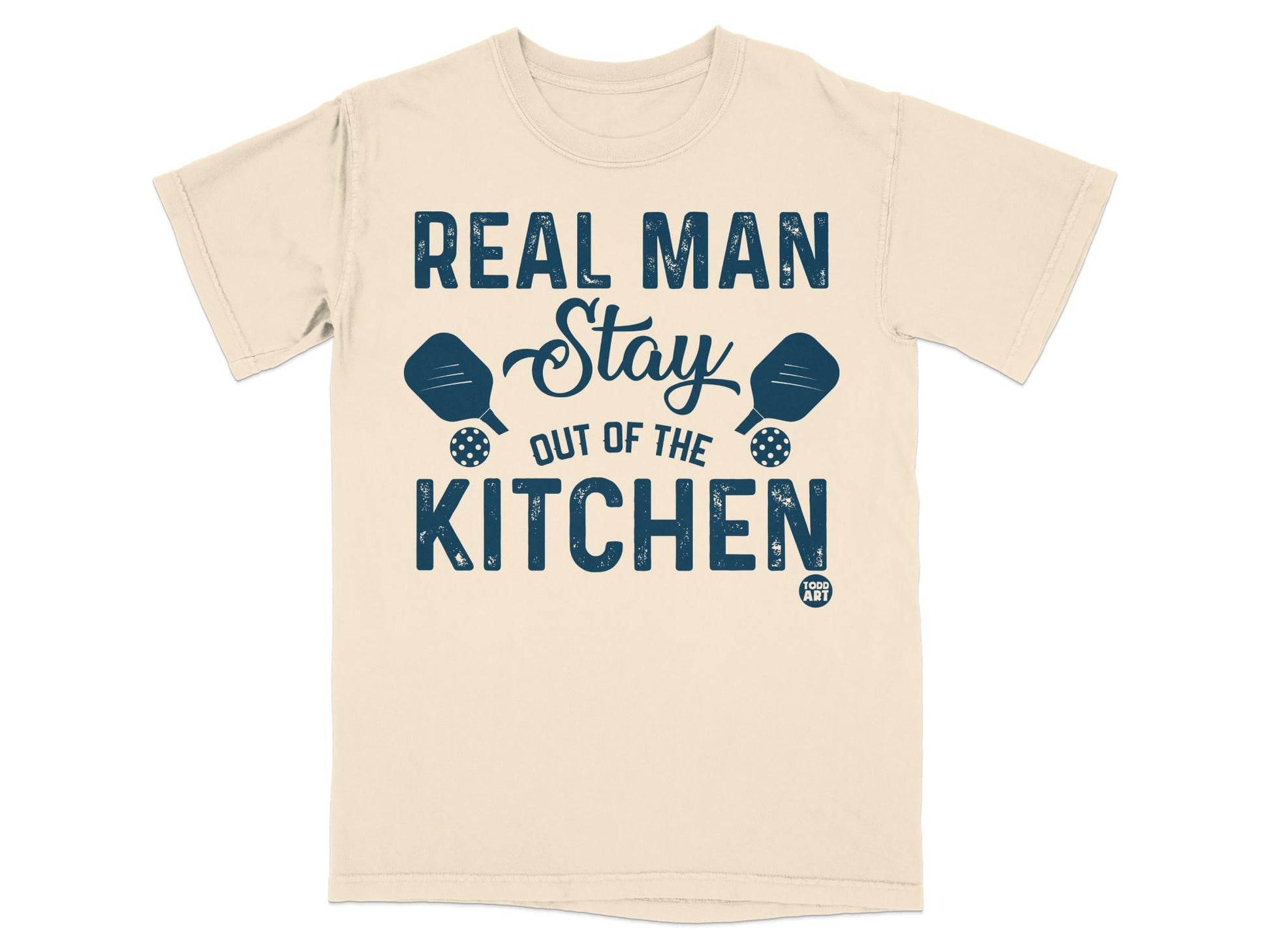 Beige t-shirt with "REAL MAN Stay OUT OF THE KITCHEN" and pickleball paddles.