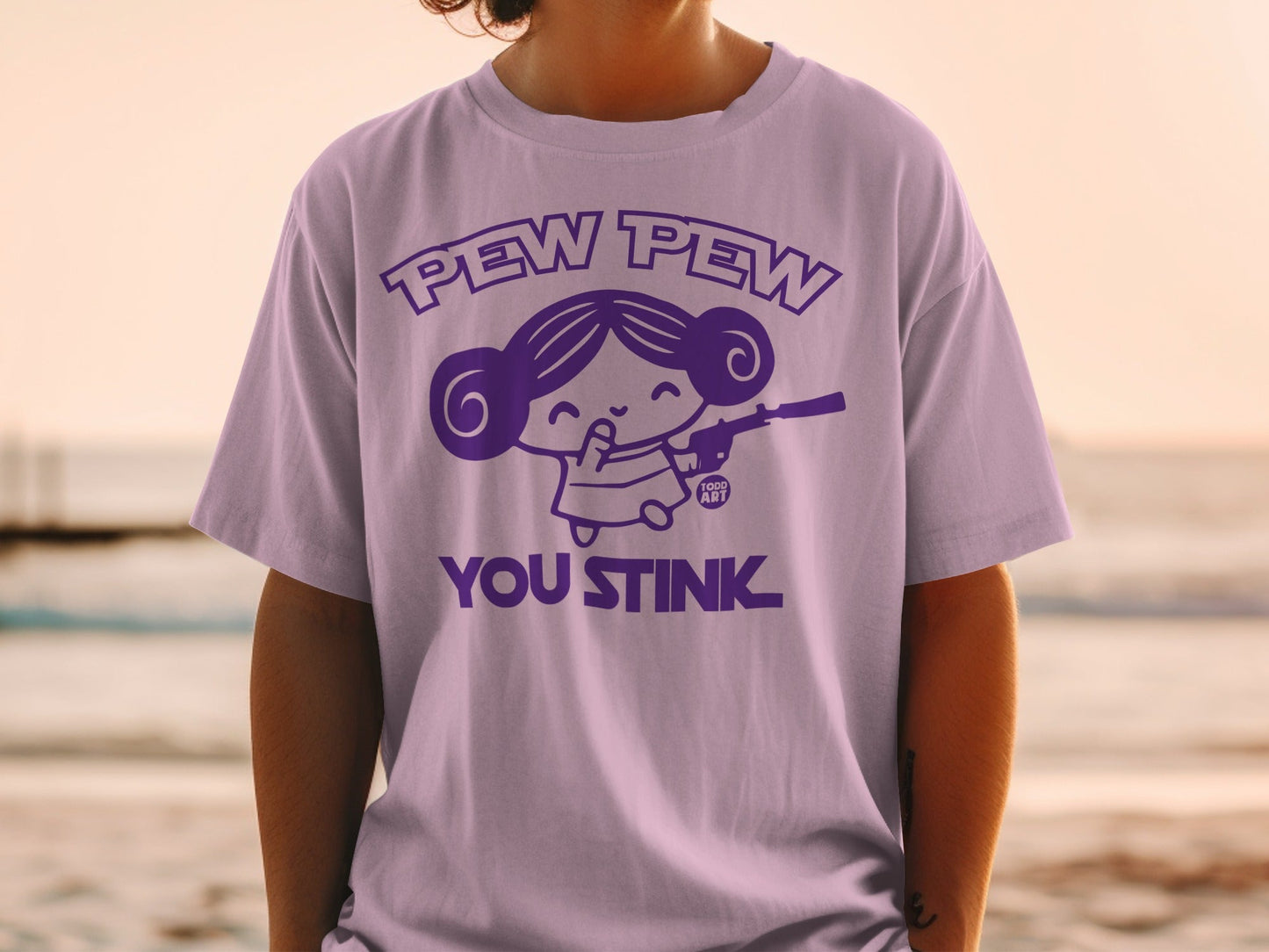 Purple t-shirt with cartoon girl holding a gun and text "Pew Pew YOU STINK".