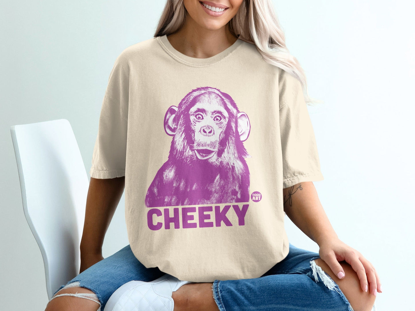 Chimpanzee graphic wearing a cream t-shirt with "CHEEKY" text.