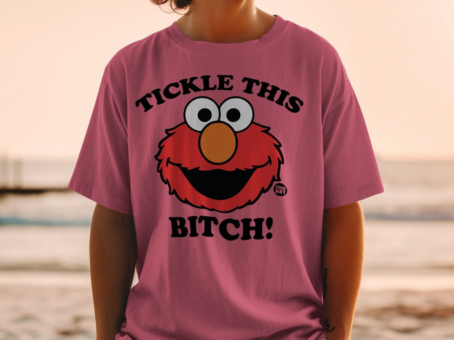 Pink t-shirt with Elmo saying "Tickle this bitch!"