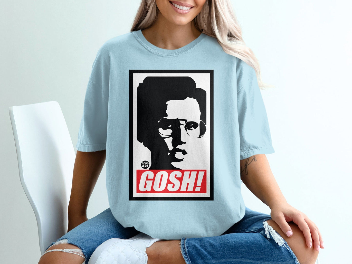 Light blue t-shirt with a black and white portrait and the word "GOSH!"