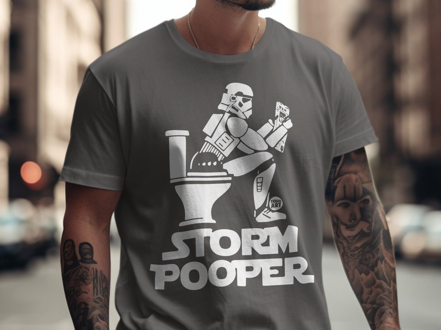 Stormtrooper sitting on a toilet, reading, on a t-shirt that says "Storm Pooper."