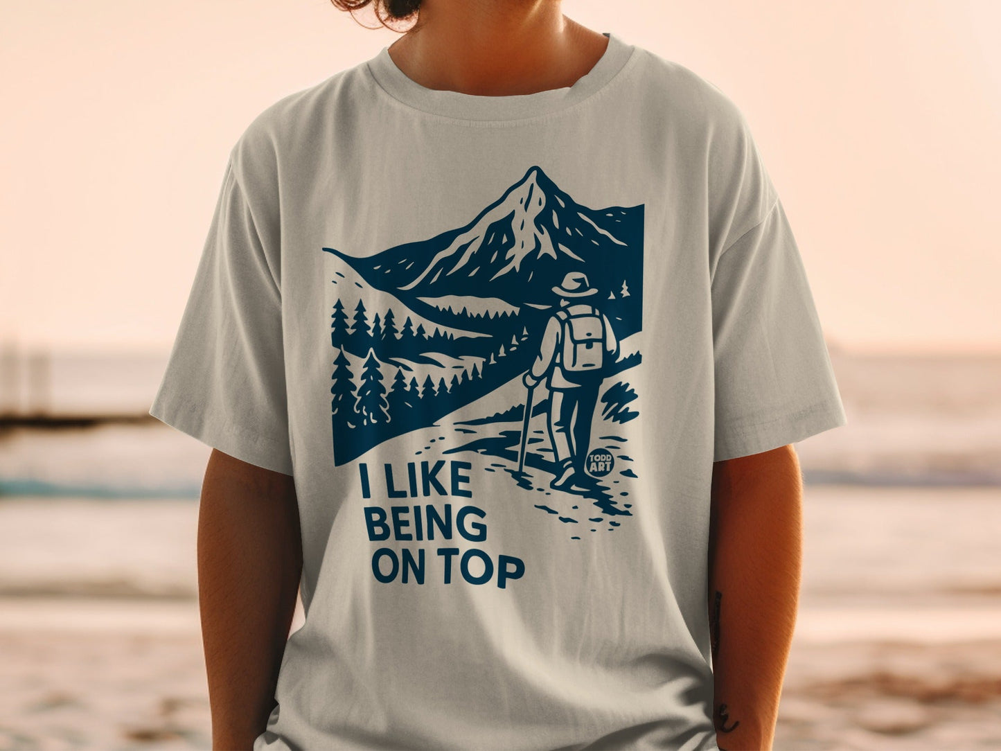 T-shirt with a graphic of a hiker and mountains, reading "I like being on top."