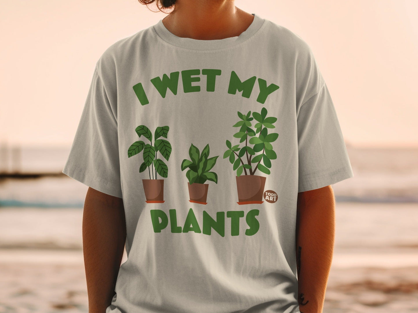 Green t-shirt with "I WET MY PLANTS" and potted plants design.