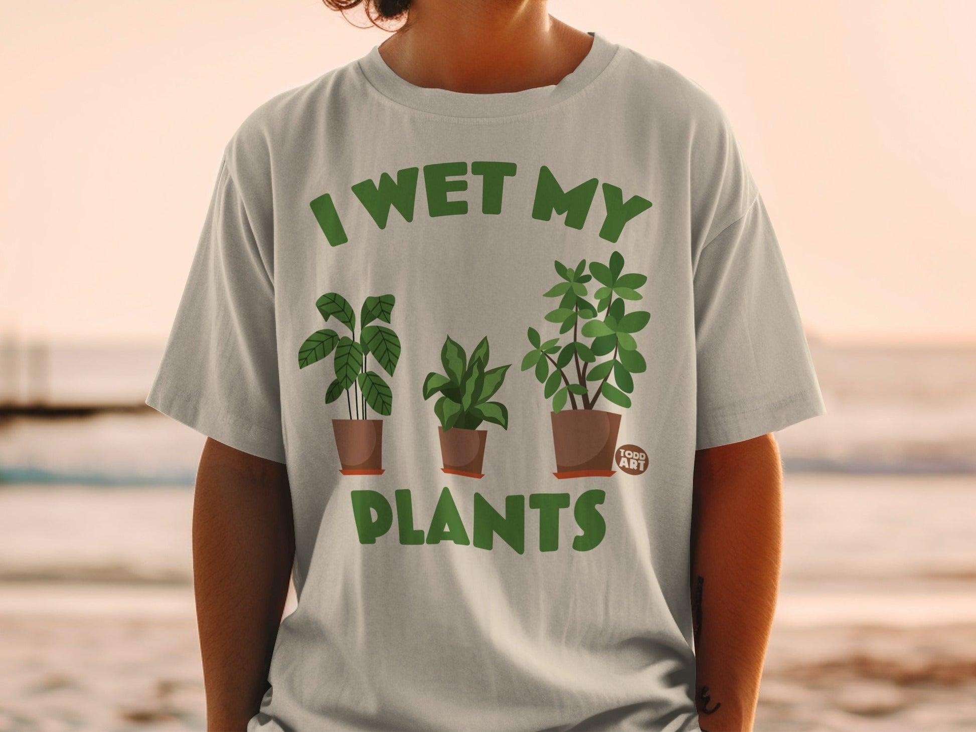 Green t-shirt with "I WET MY PLANTS" and potted plants design.