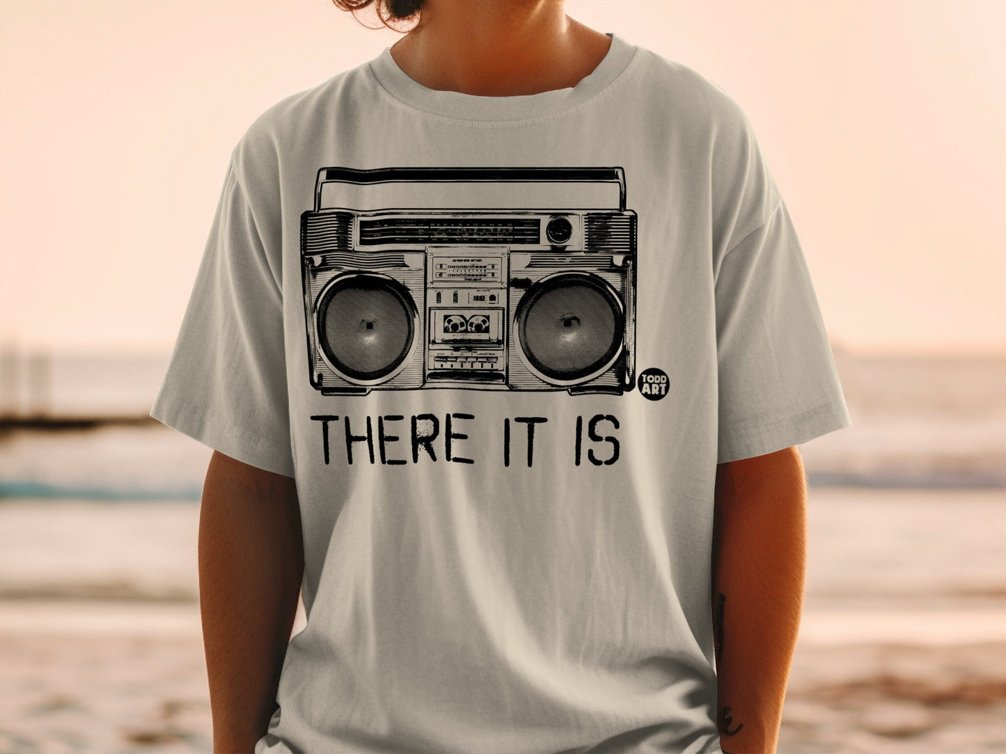 Grey t-shirt with a vintage boombox illustration and "THERE IT IS" text.