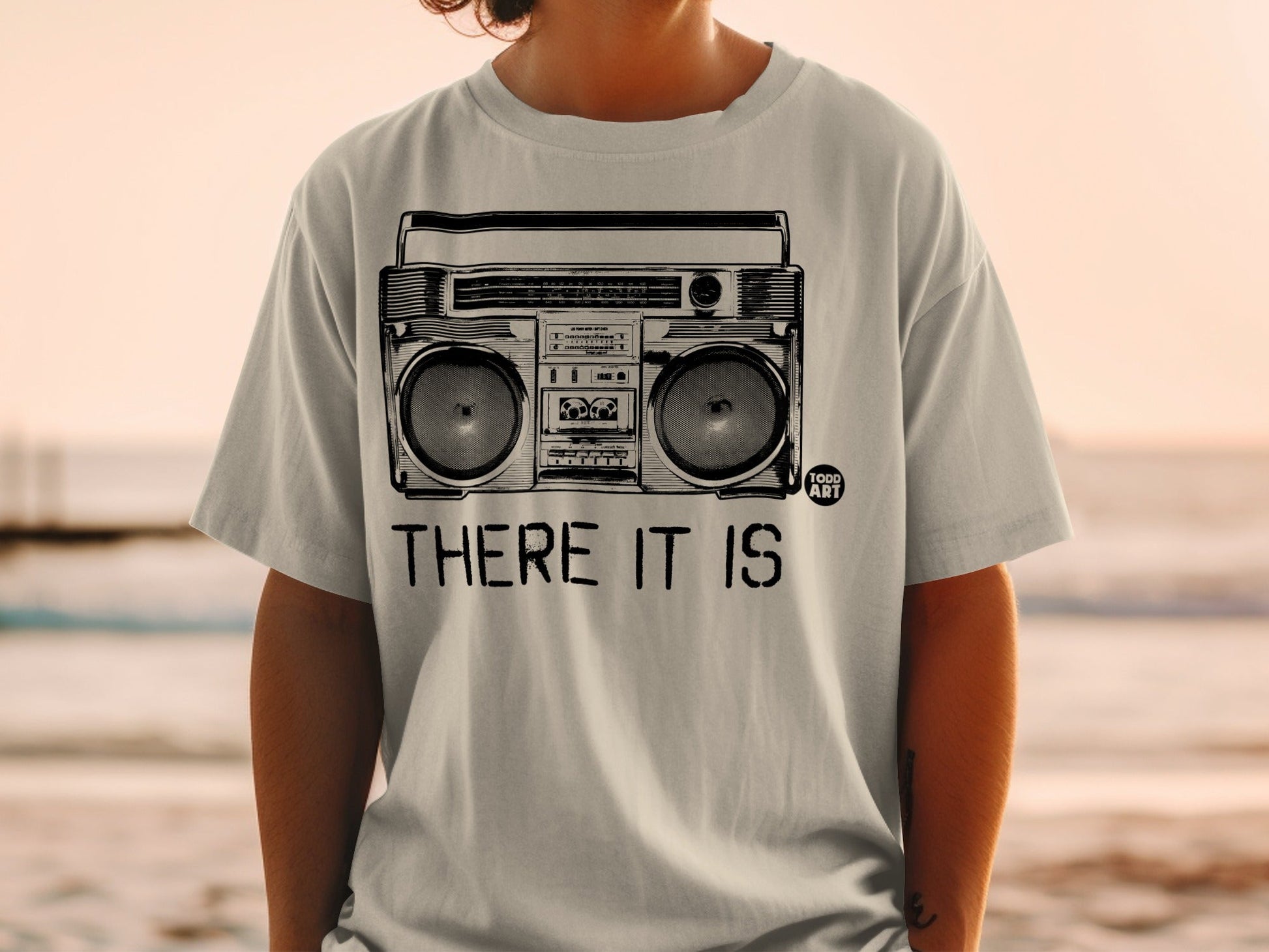 Grey t-shirt with a vintage boombox illustration and "THERE IT IS" text.