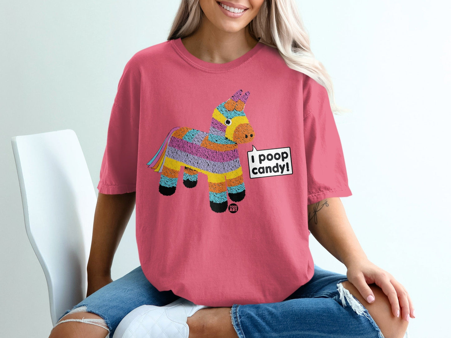 Pink t-shirt with a colorful pi√±ata design and "I poop candy!" speech bubble.