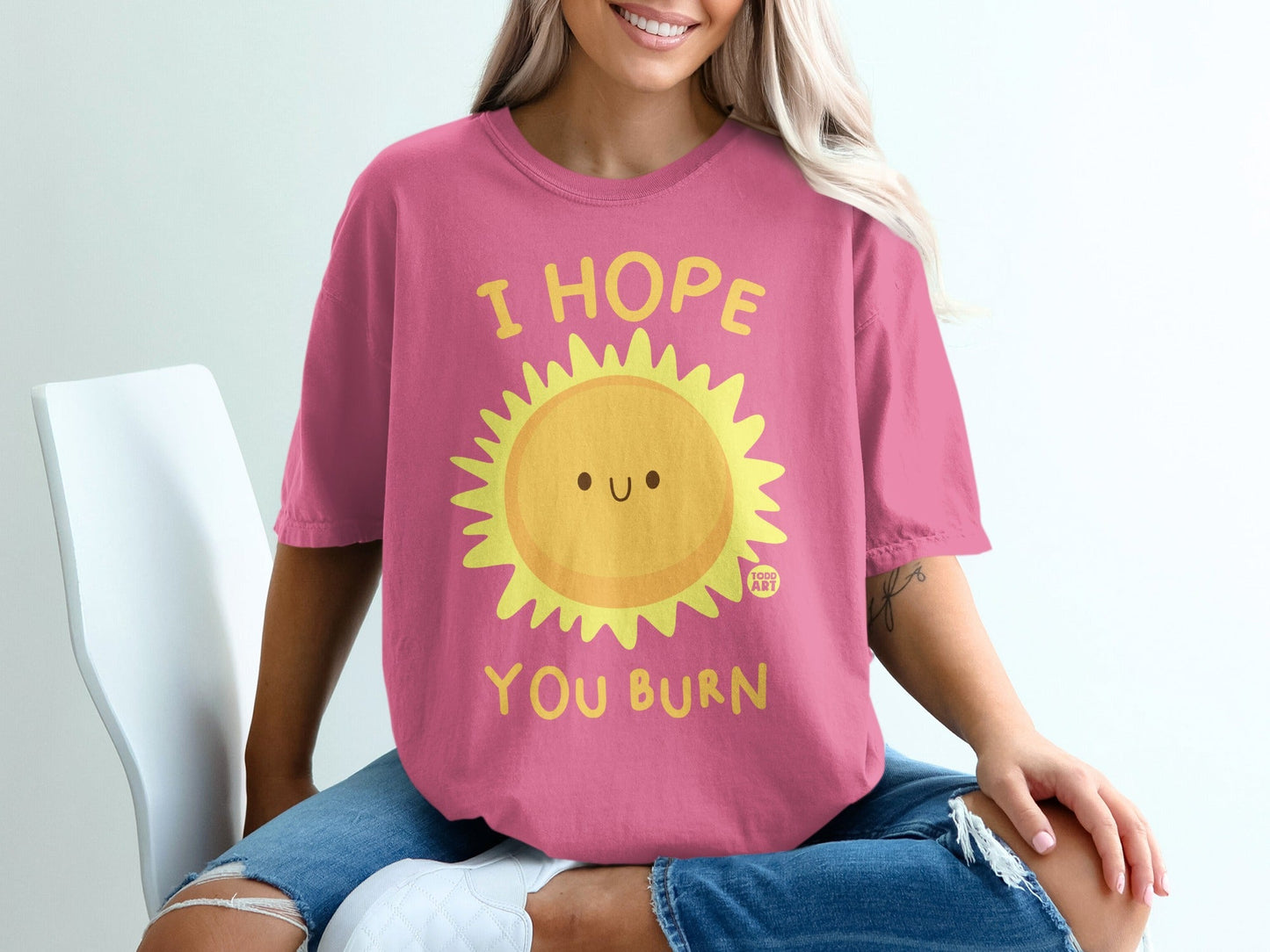 Pink t-shirt with smiling sun graphic and text "I HOPE YOU BURN".