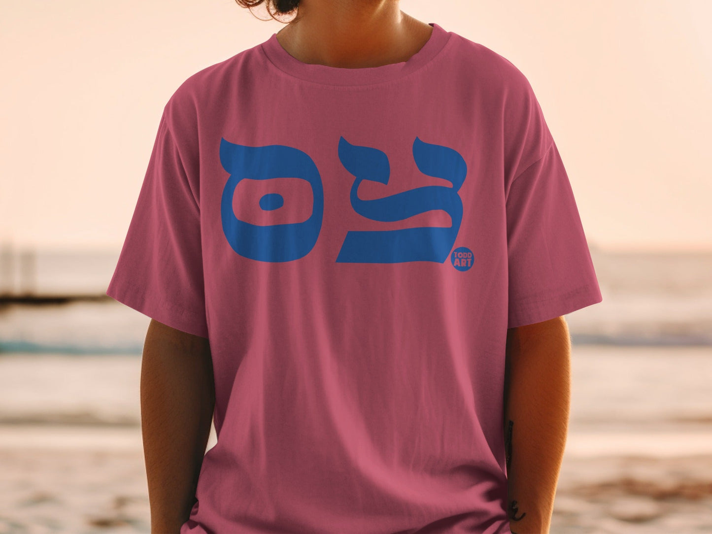Pink t-shirt with bold blue Hebrew letters "HOOD ART" logo.