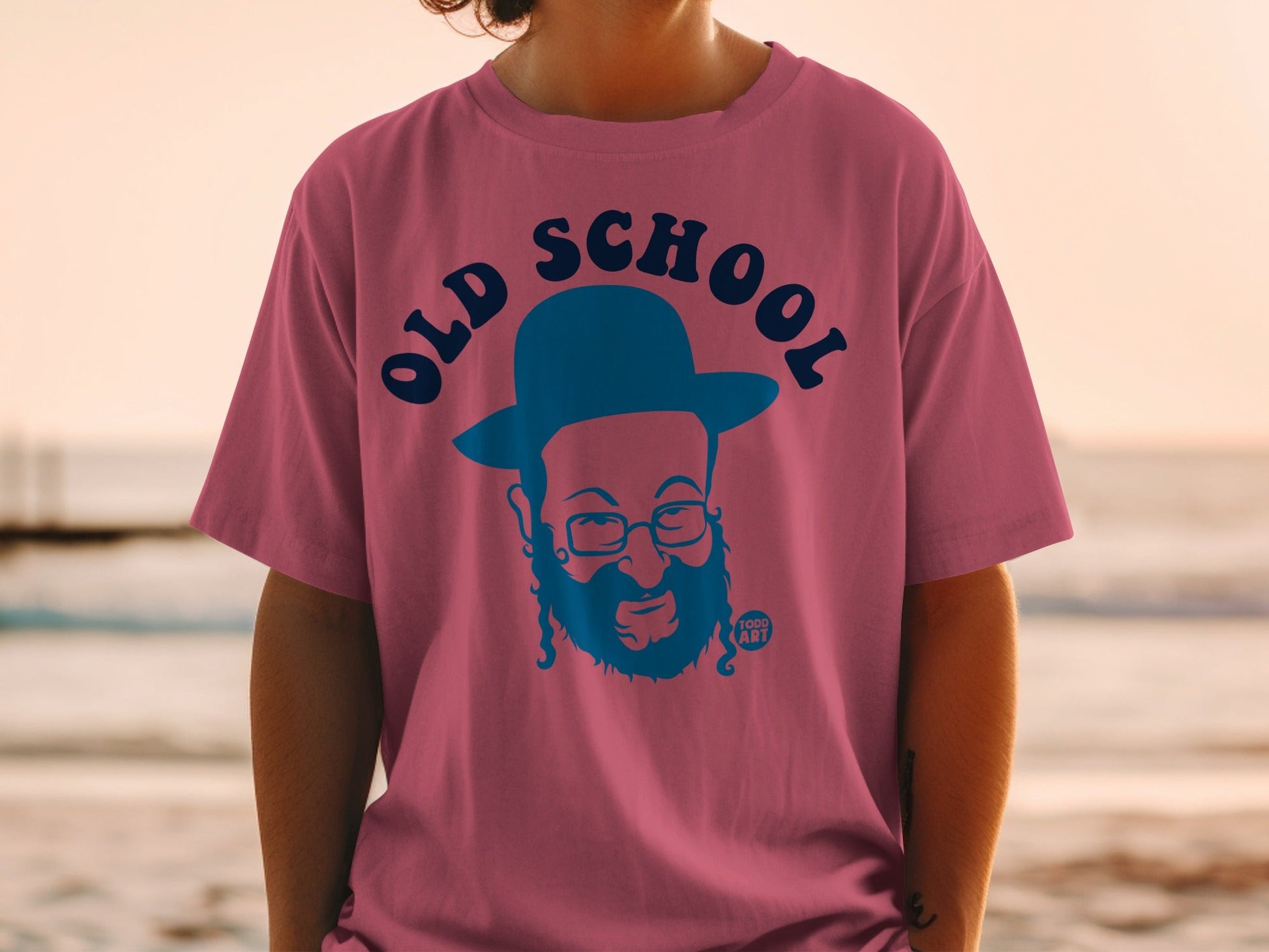 Pink t-shirt with blue "Old School" graphic and bearded man in a hat.