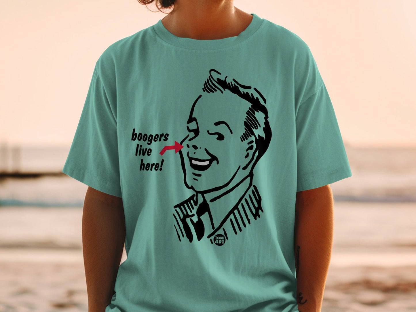 Teal t-shirt with graphic of a man's face and "boogers live here!" text.