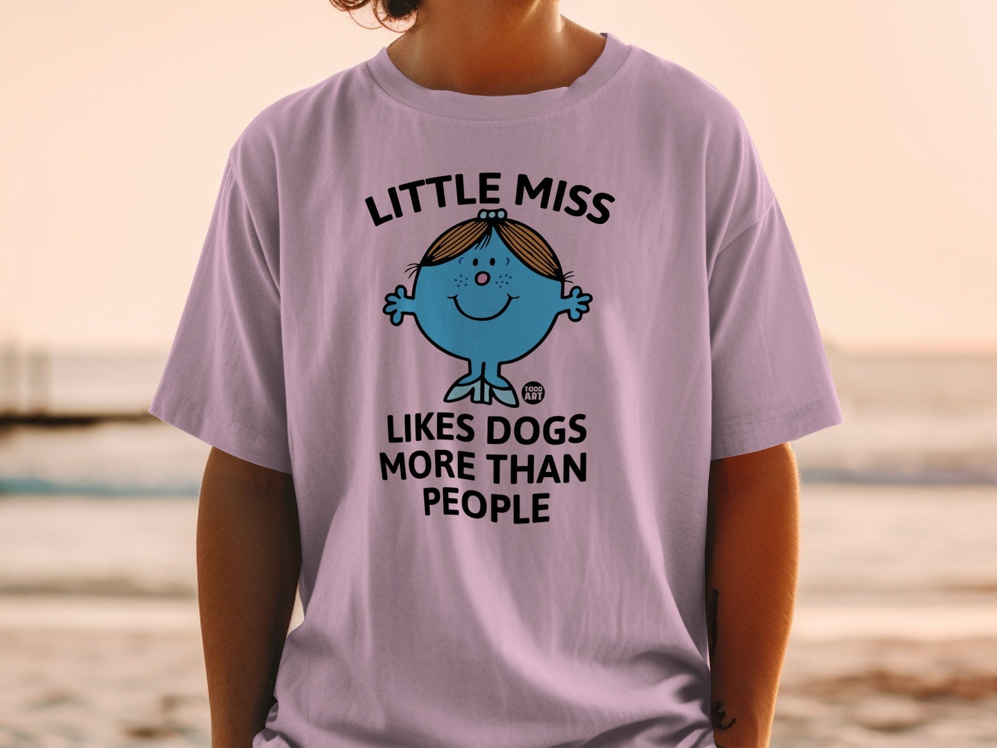 Purple t-shirt with "Little Miss Likes Dogs More Than People" text and cartoon.