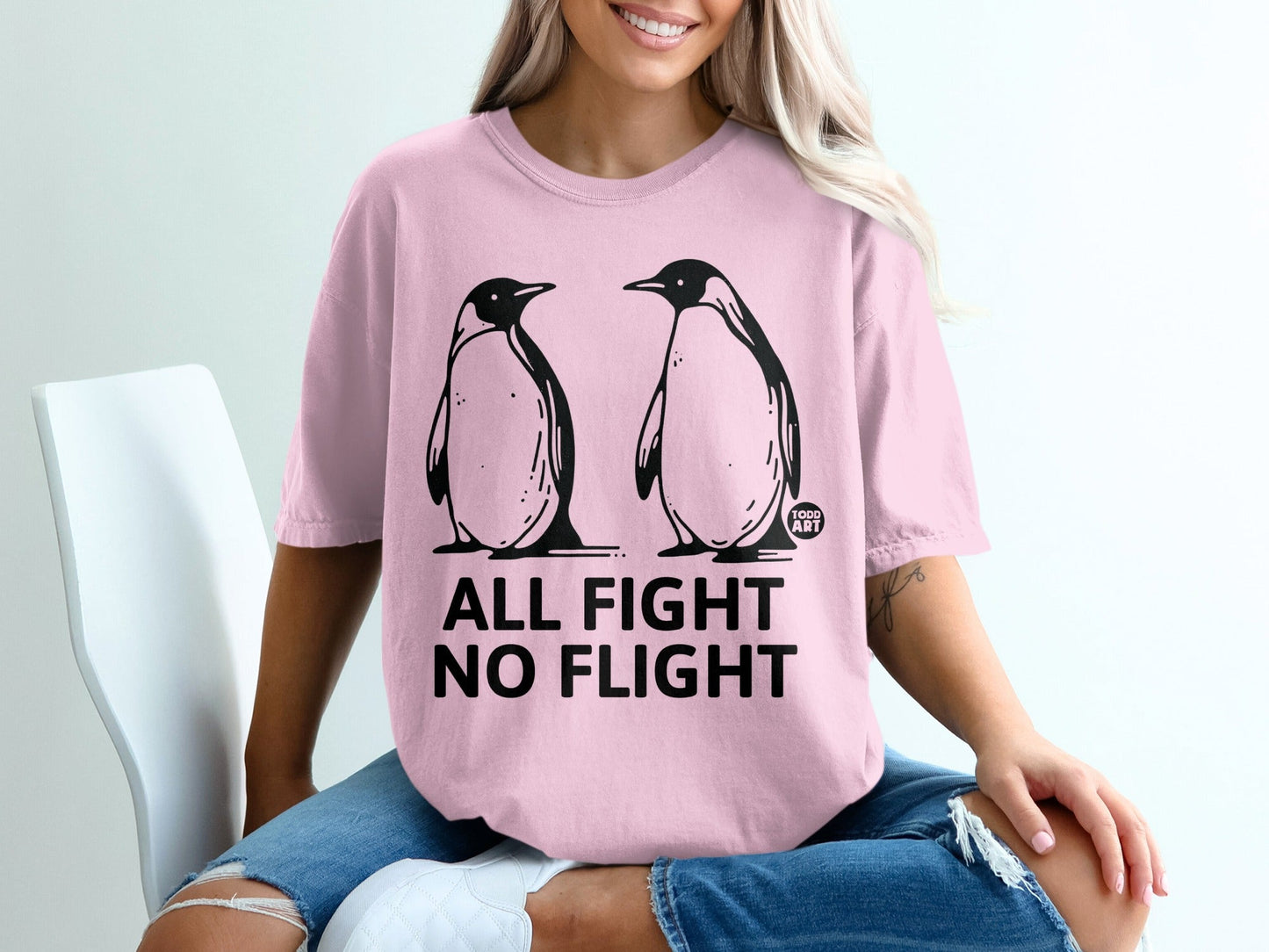 Pink t-shirt with two penguins and text "ALL FIGHT NO FLIGHT".