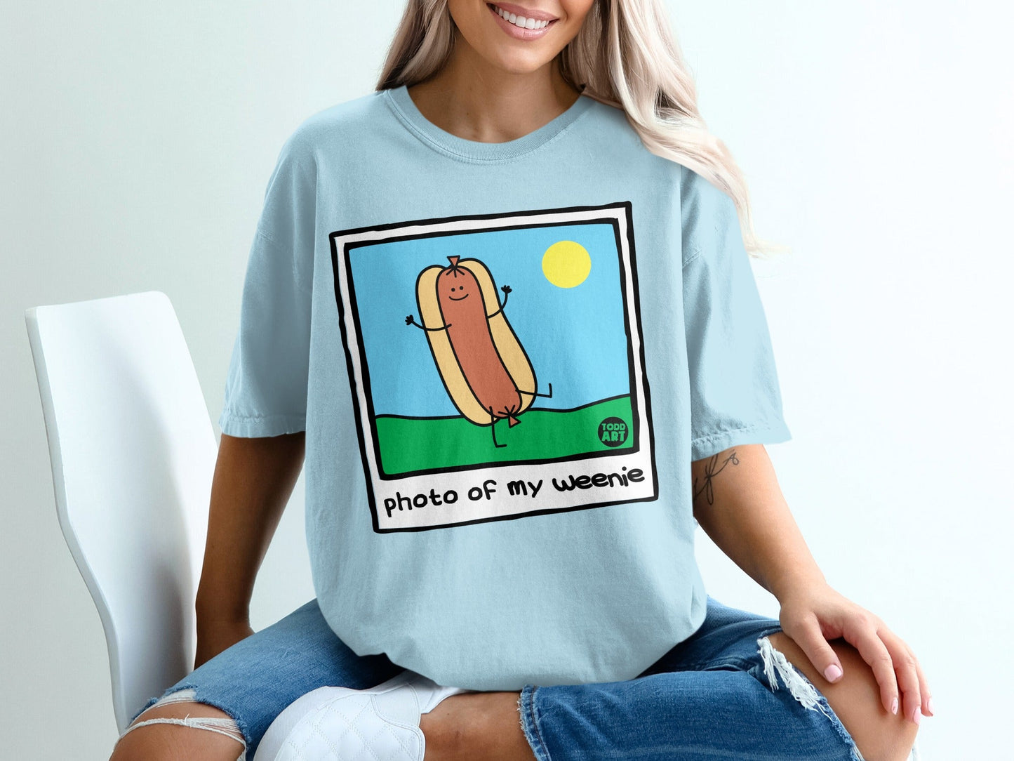 Cartoon hot dog with smiling face and arms raised on grass under a sun.
