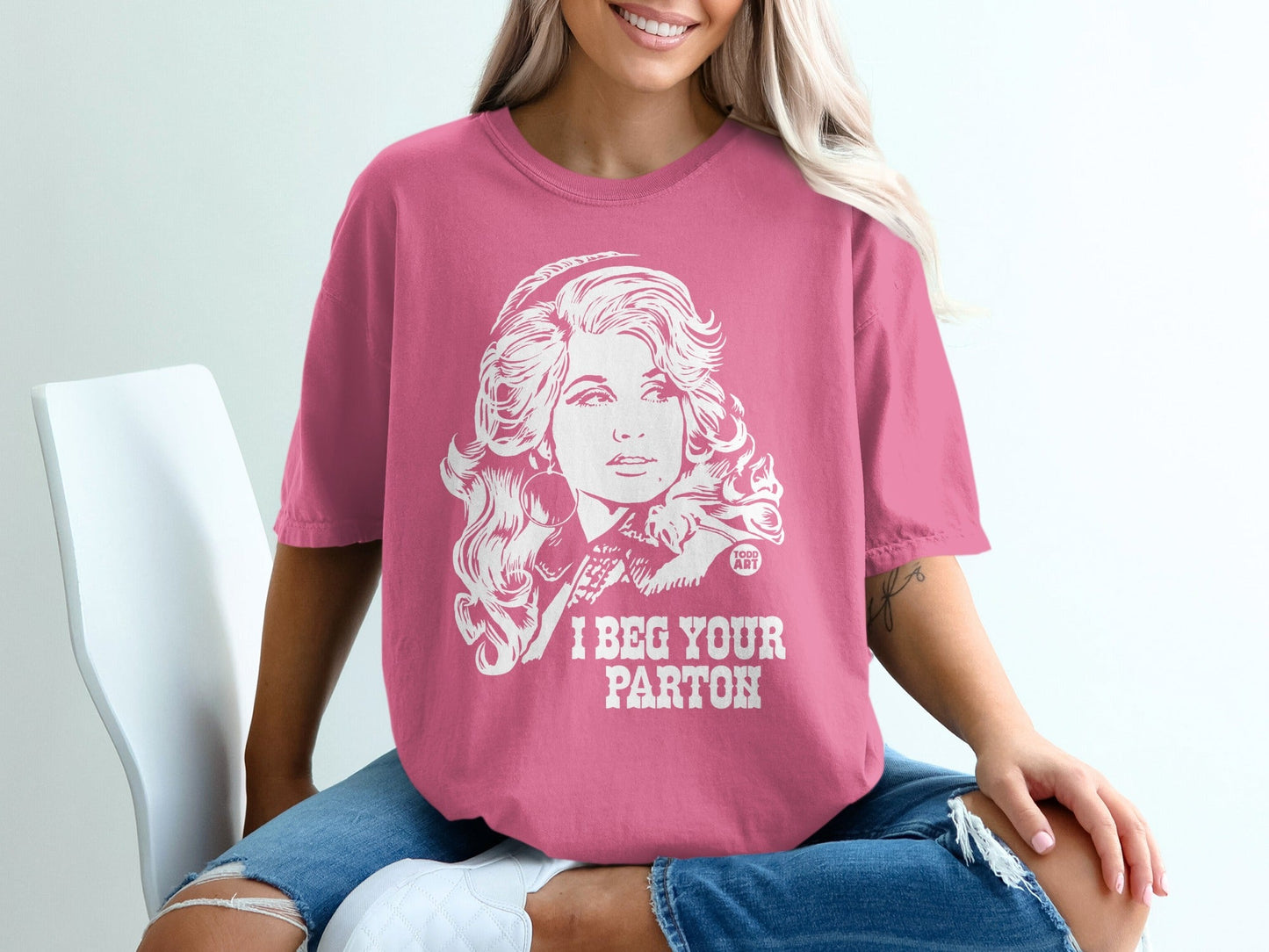 Pink t-shirt with Dolly Parton portrait and "I BEG YOUR PARTON" text.