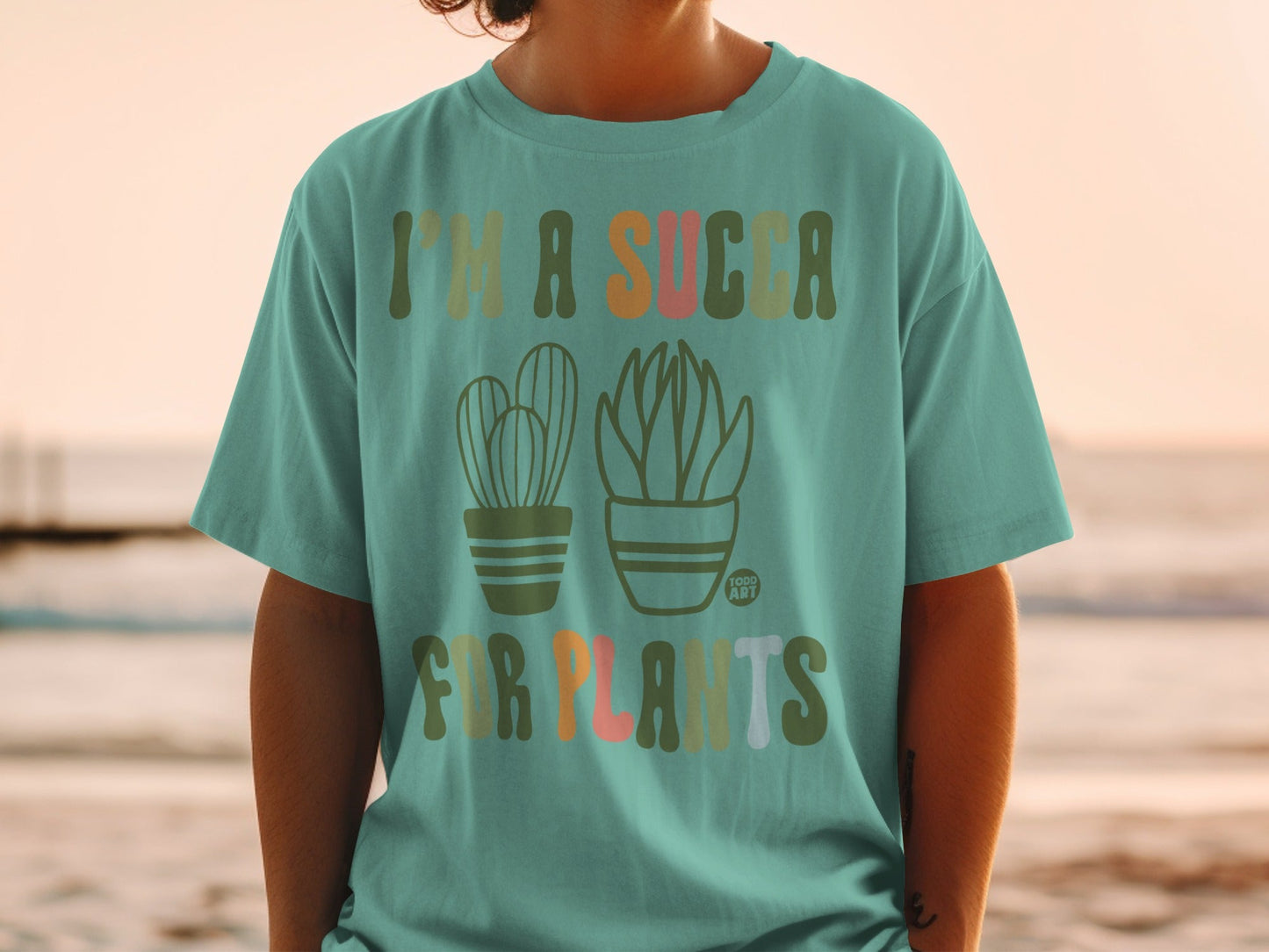 Teal t-shirt with cacti and succulents and text "I'm a succa for plants."