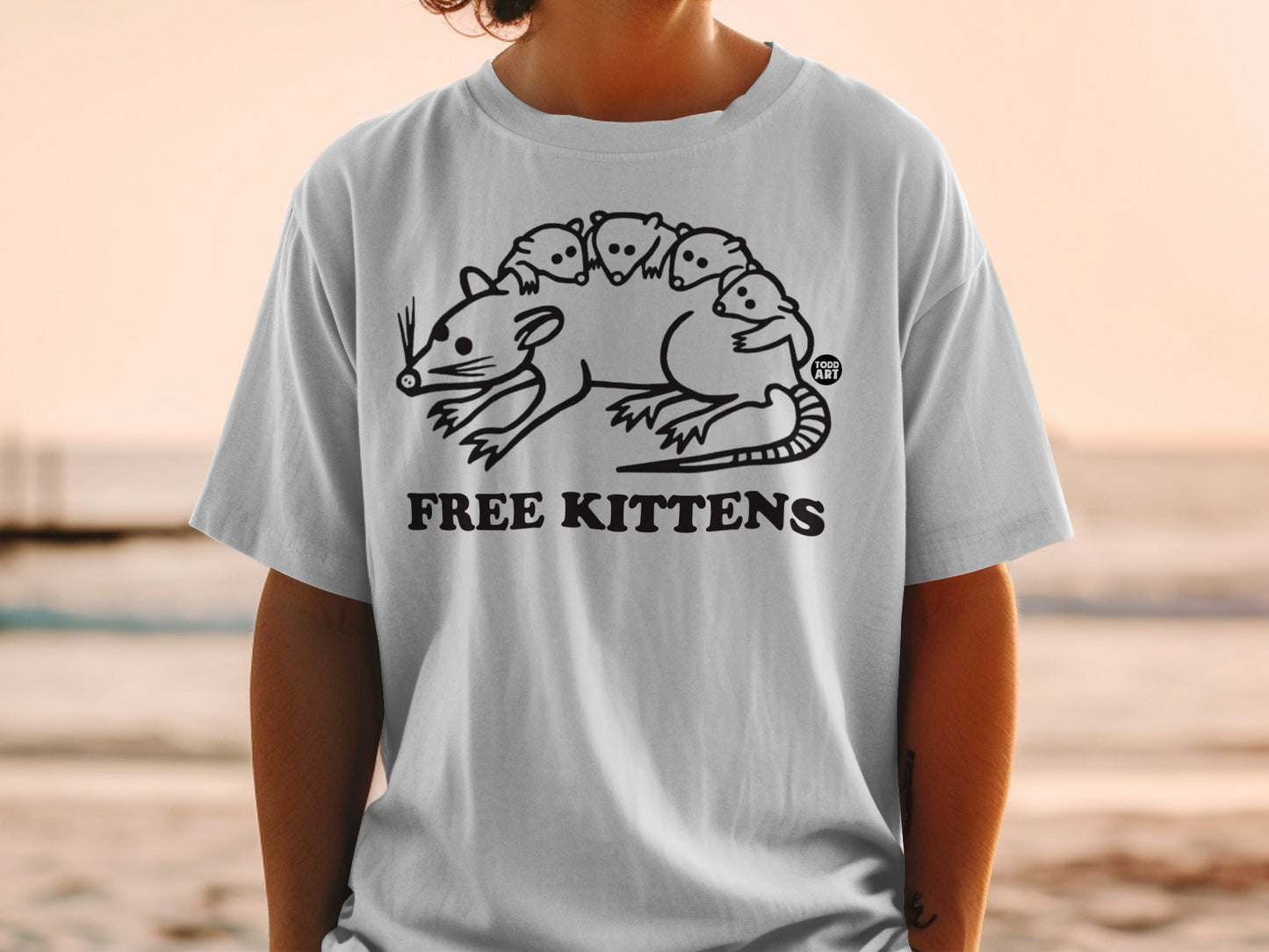 T-shirt with graphic of a large rodent carrying several small kittens on its back.