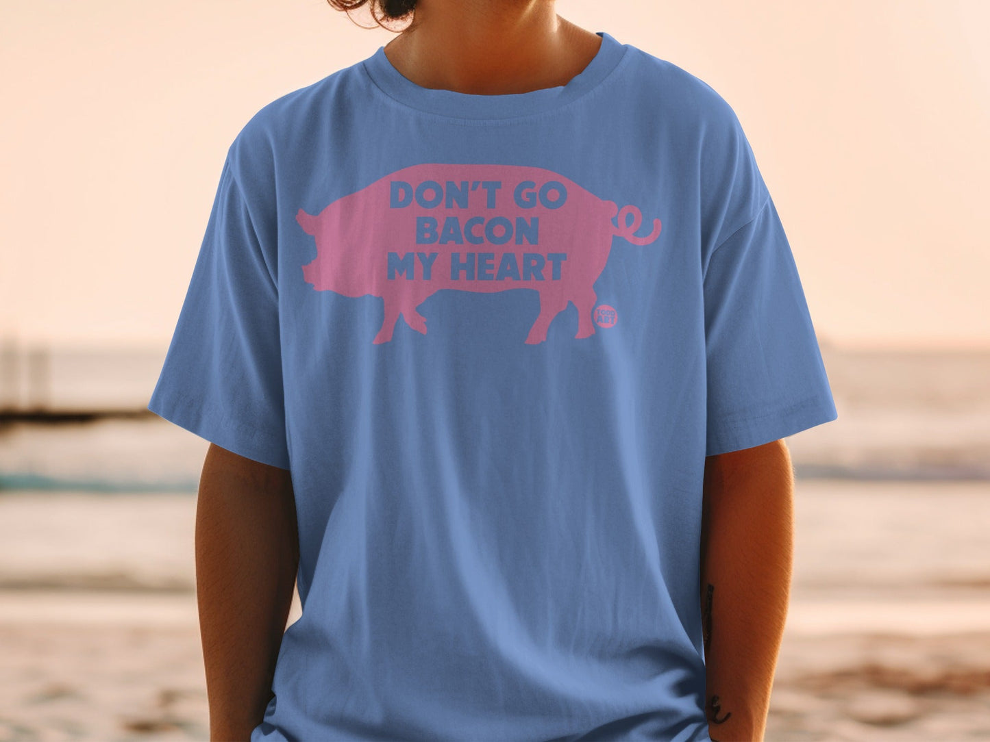 Blue t-shirt with pink pig graphic and text "Don't Go Bacon My Heart".