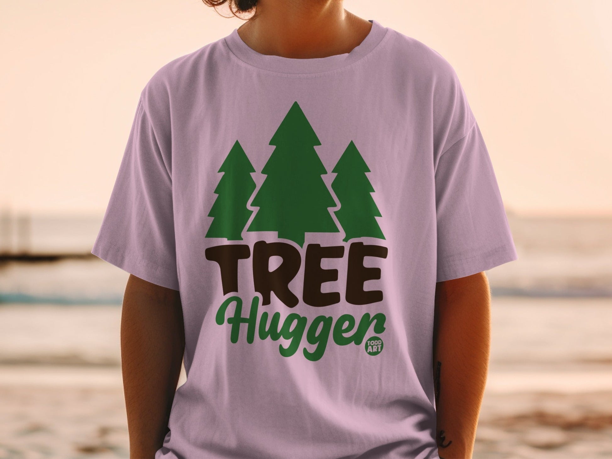 Lilac t-shirt with green trees and "TREE Hugger" text.
