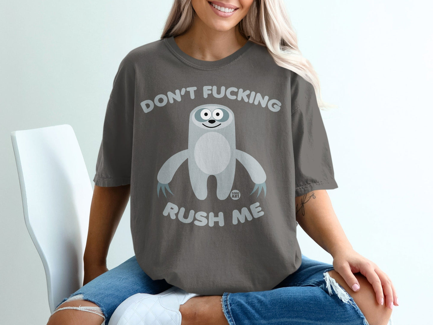 Dark gray t-shirt with a cartoon sloth and text "DON'T FUCKING RUSH ME".