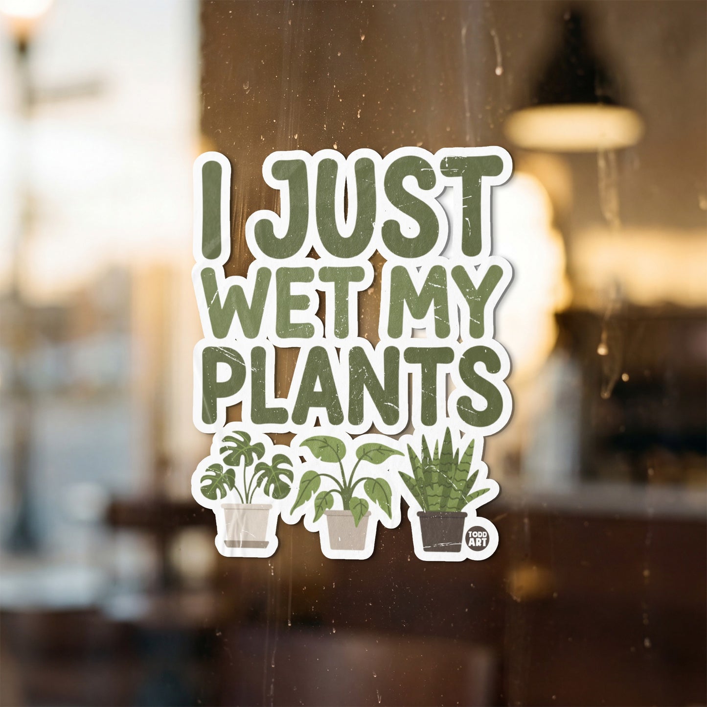 Sticker with green text "I JUST WET MY PLANTS" and three potted plants.