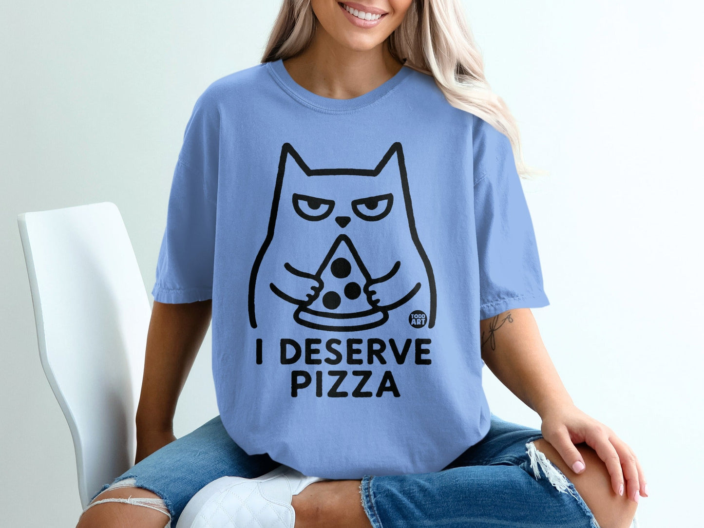 Blue t-shirt with a cartoon cat holding a slice of pizza and text that reads "I DESERVE PIZZA."