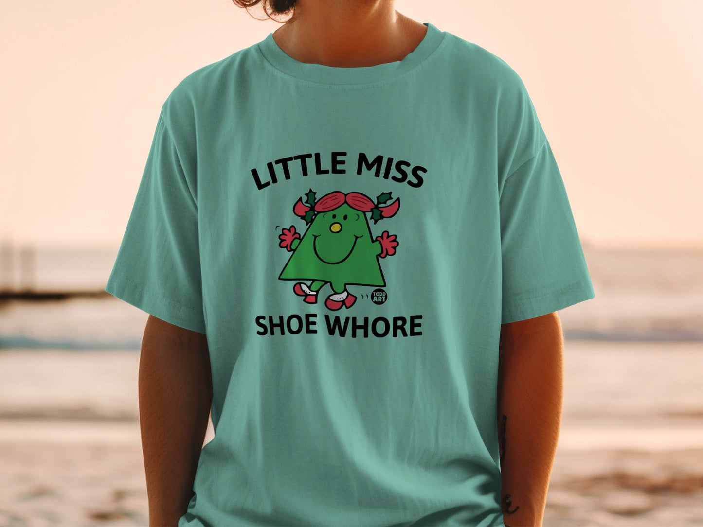Green t-shirt with "LITTLE MISS SHOE WHORE" text and cartoon character.