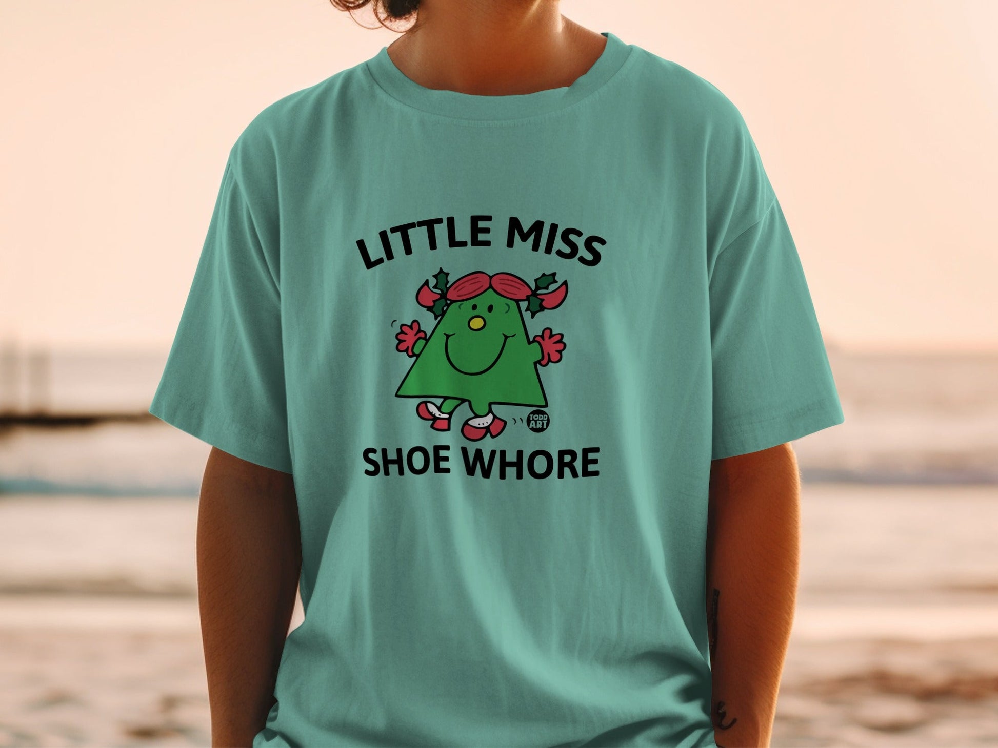 Green t-shirt with "LITTLE MISS SHOE WHORE" text and cartoon character.