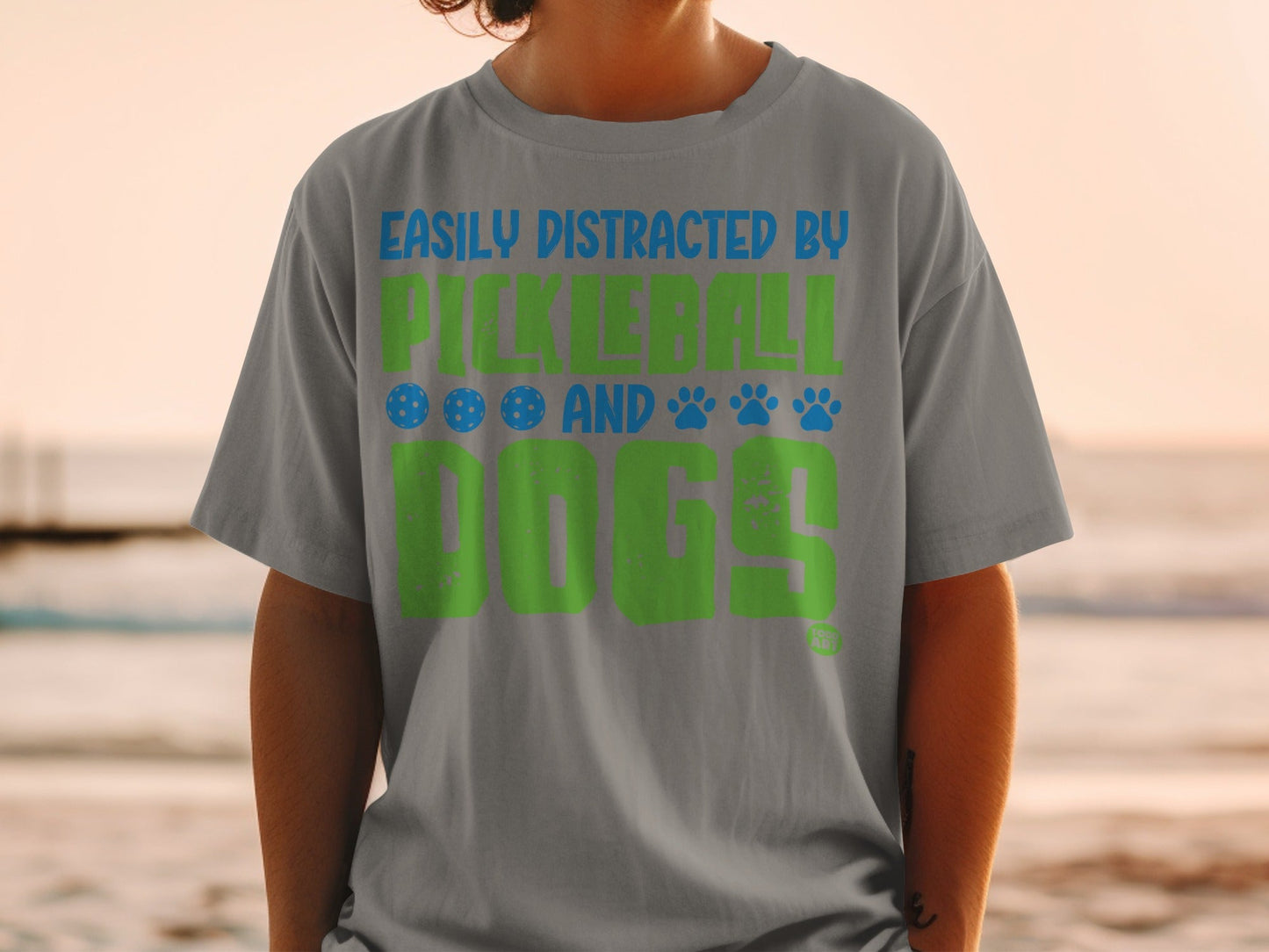 Gray t-shirt with "Easily Distracted by Pickleball and Dogs" in green and blue.