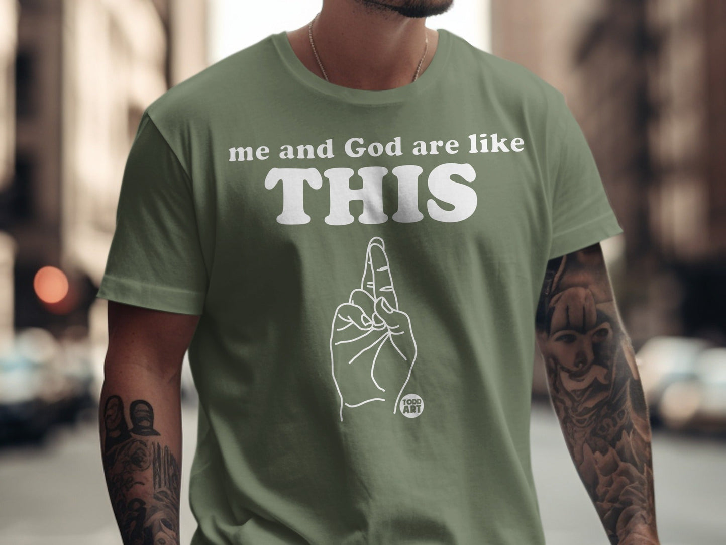 Green t-shirt with "me and God are like THIS" text and a hand gesture.