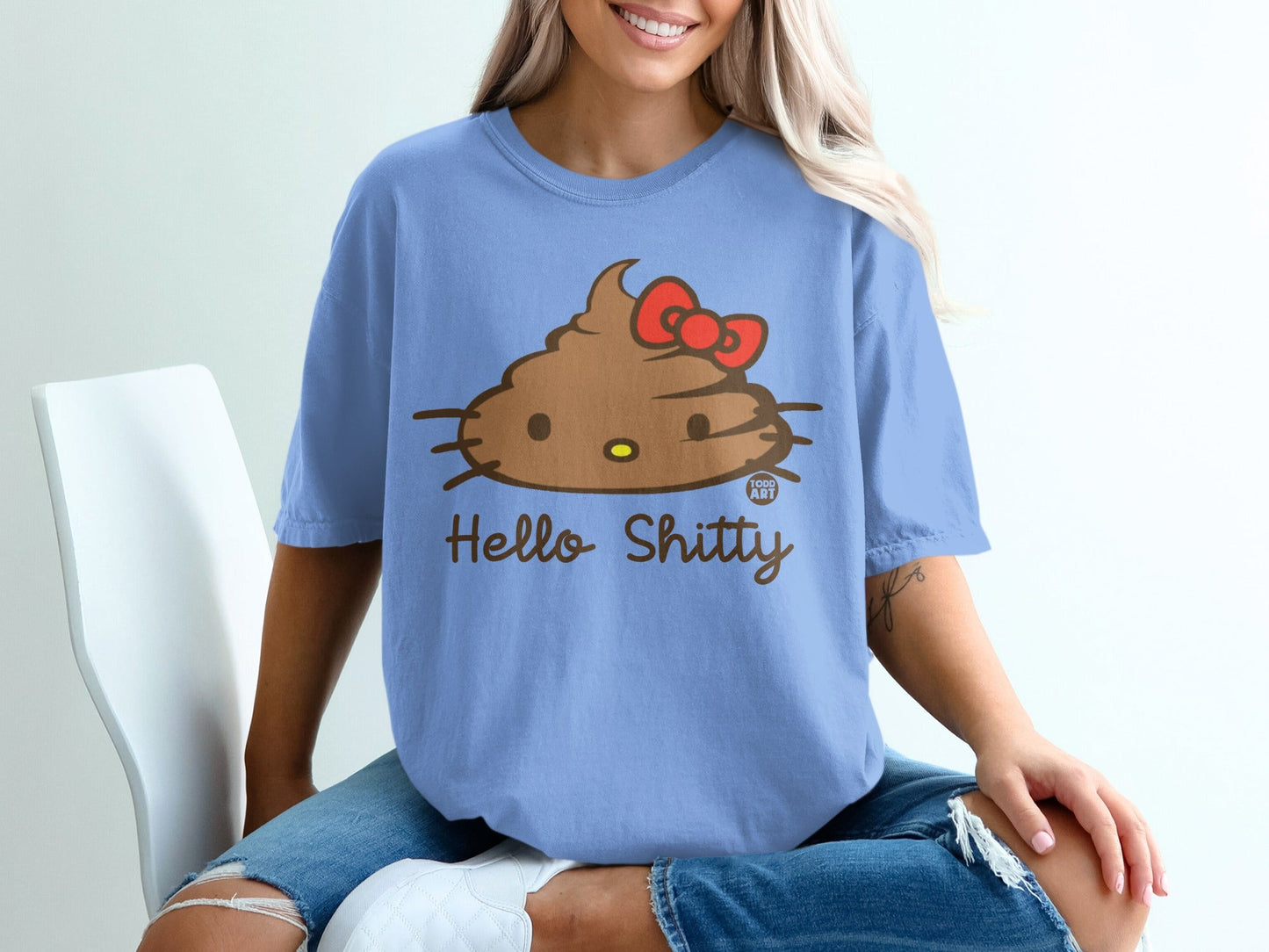 Blue t-shirt with a brown Hello Kitty poop emoji and red bow graphic.