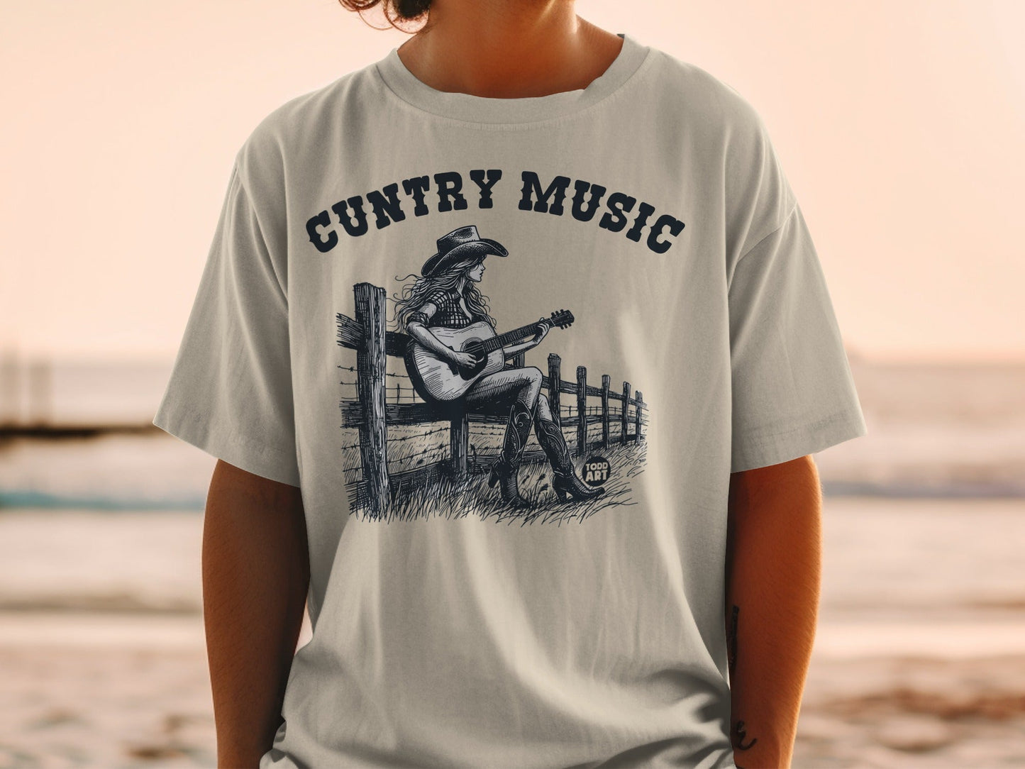 Country Music graphic tee with a woman playing guitar on a fence.