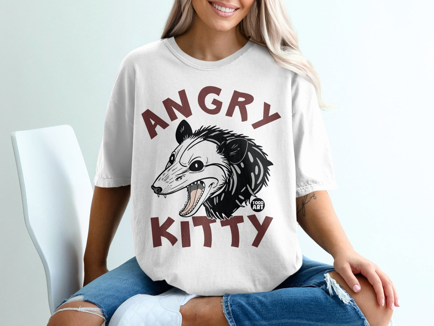 White t-shirt with an angry possum graphic and "ANGRY KITTY" text.