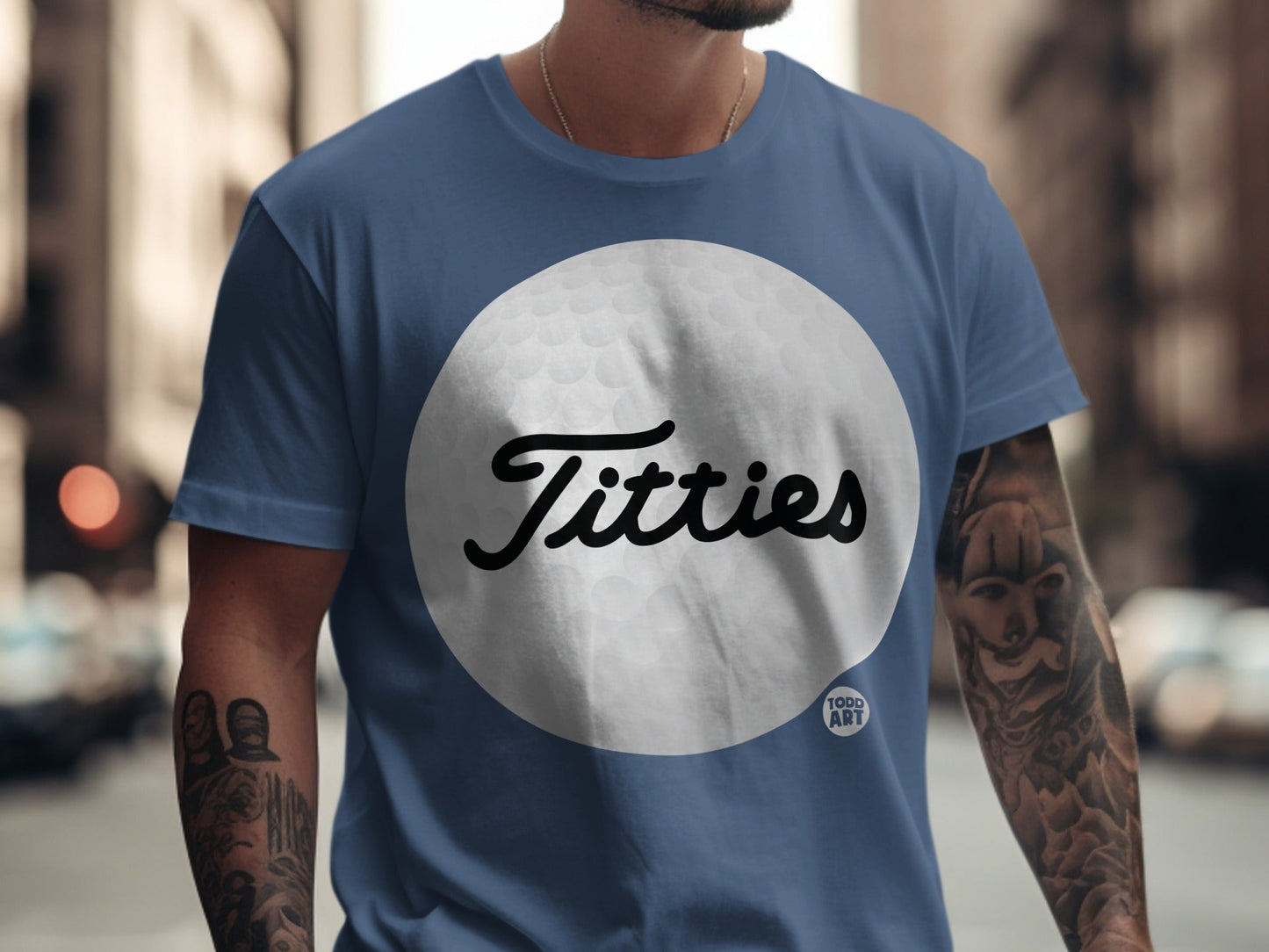 Blue t-shirt with "Titties" in script over a golf ball graphic.