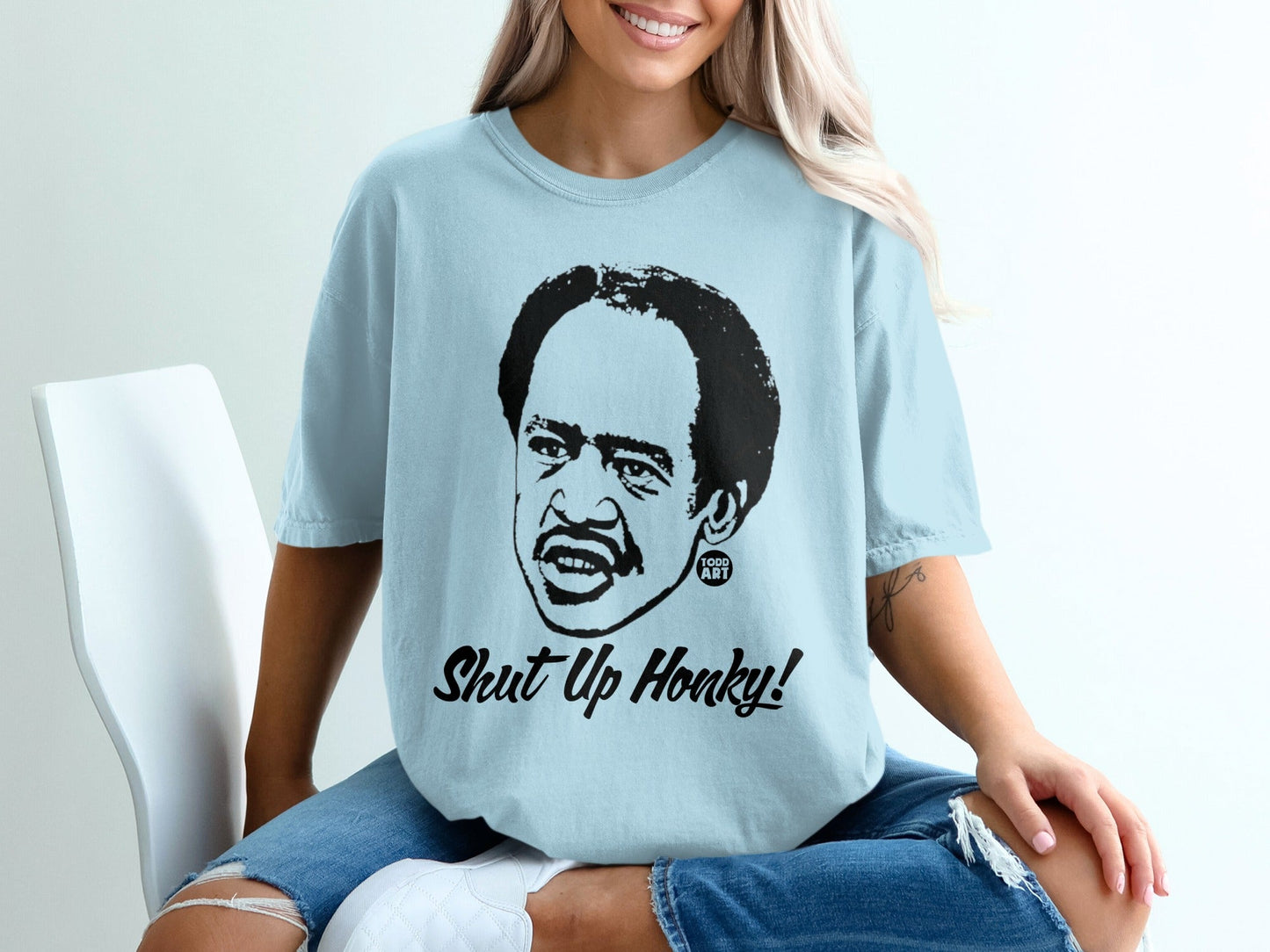 Light blue t-shirt with cartoon portrait of Redd Foxx and "Shut Up Honky!" text.