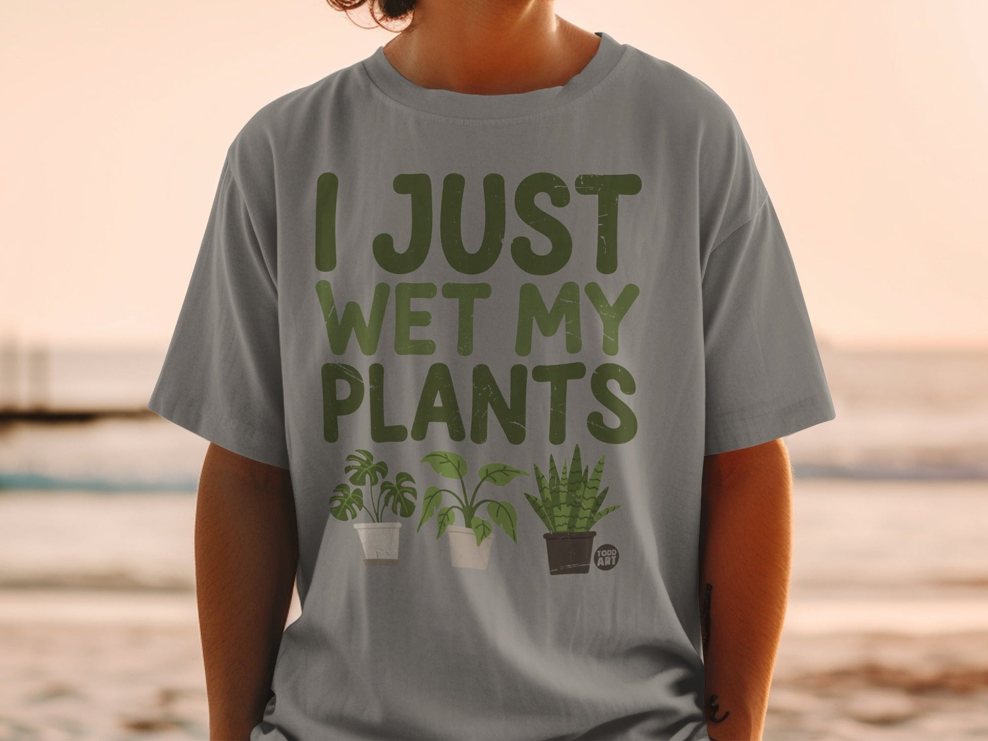 Grey t-shirt with "I just wet my plants" and plant illustrations.