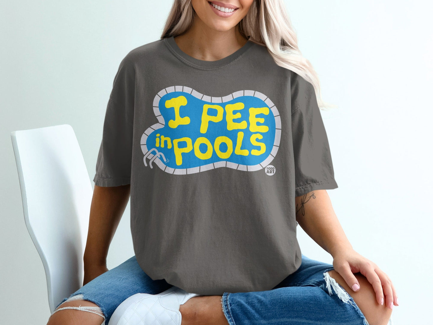 Dark gray t-shirt with yellow text "I PEE IN POOLS" inside a pool shape.