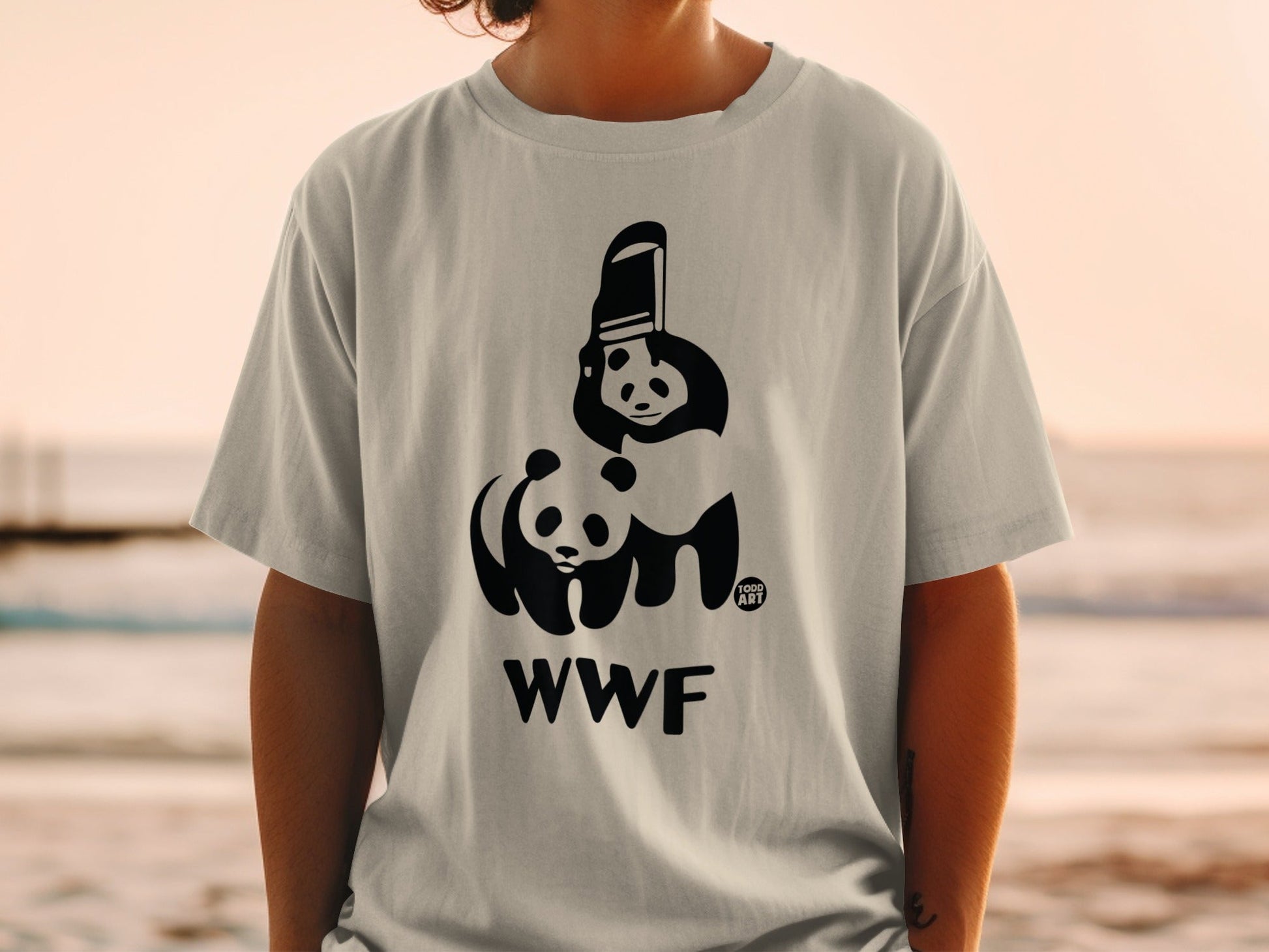Black WWF panda logo on a light gray t-shirt, worn by a person.