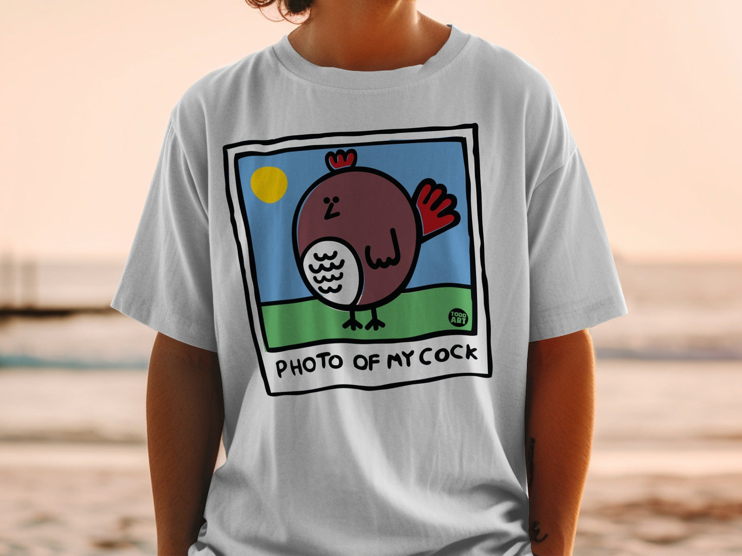 White t-shirt with a cartoon chicken in a frame and the text "PHOTO OF MY COCK".