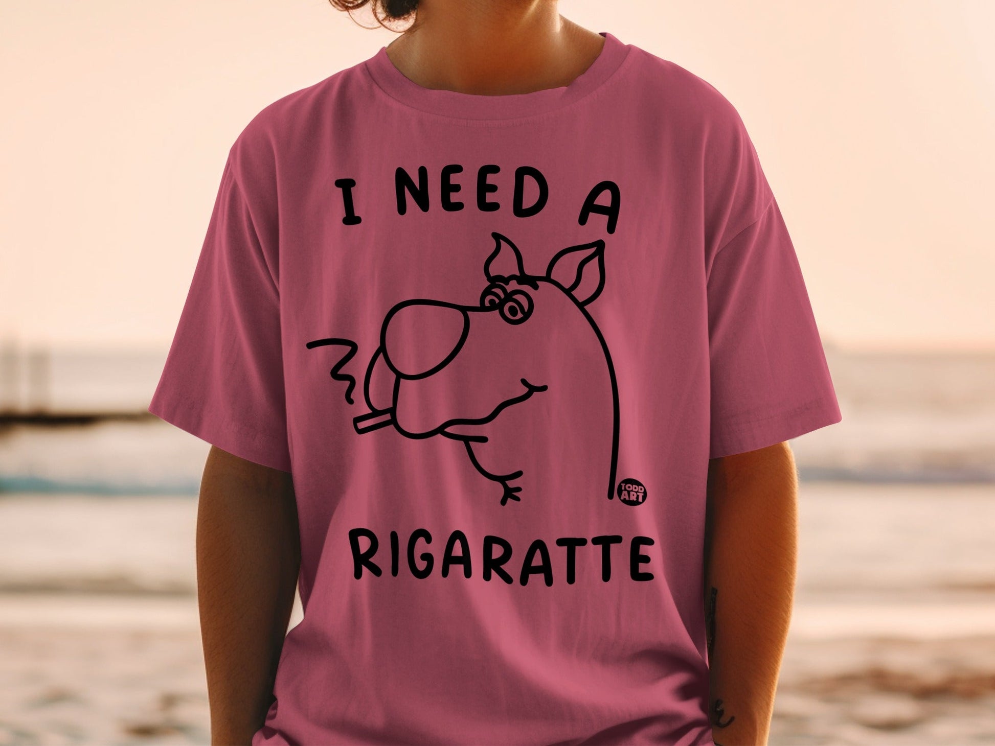 Pink t-shirt with Scooby-Doo cartoon smoking and text "I NEED A RIGARETTE".