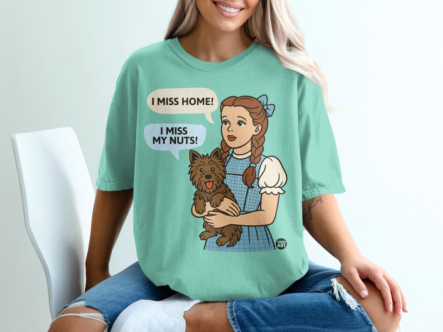 Dorothy in blue dress holding Toto, with speech bubbles saying "I MISS HOME!" and "I MISS MY NUTS!".