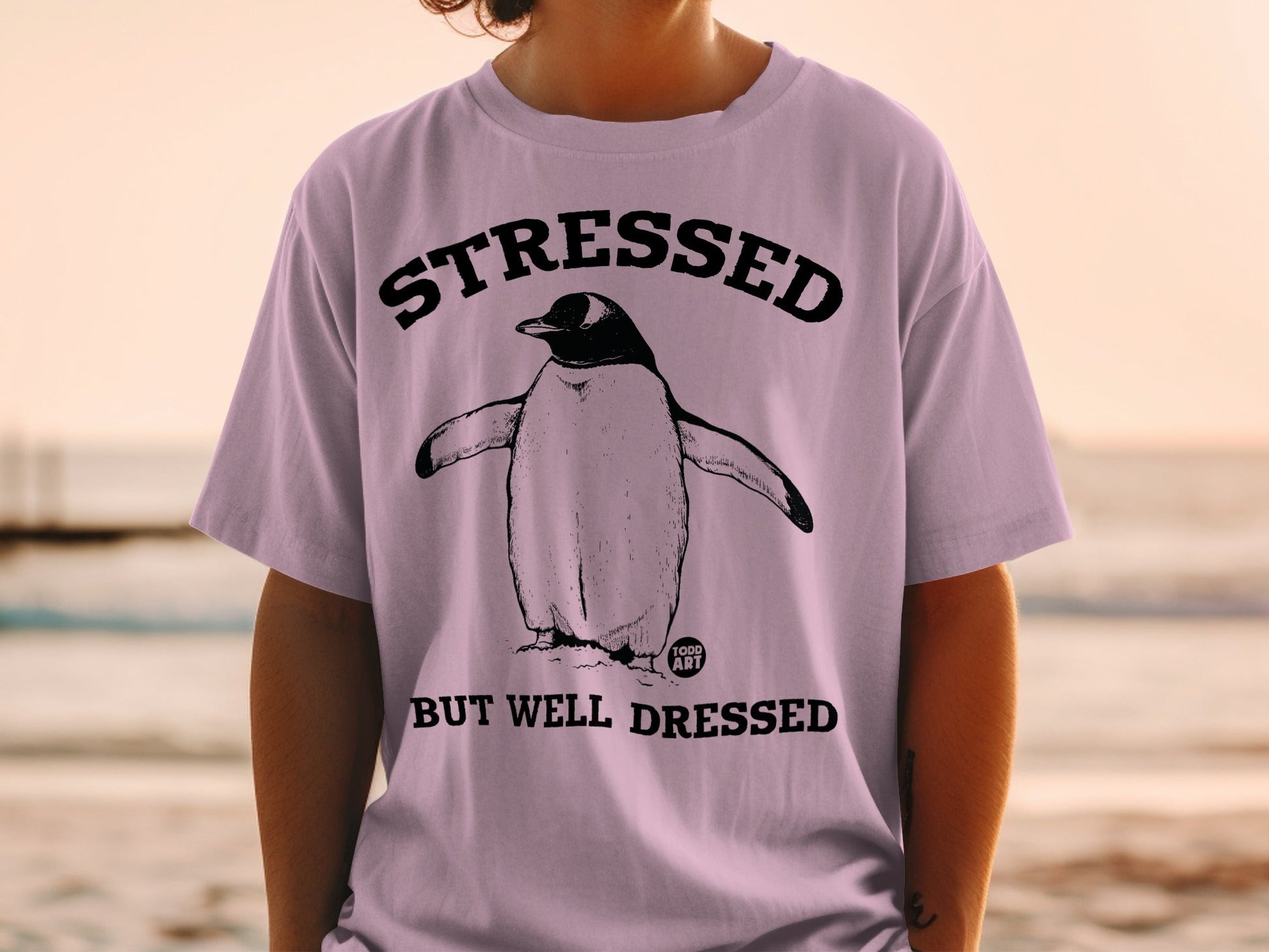 T-shirt with penguin and text "STRESSED BUT WELL DRESSED".