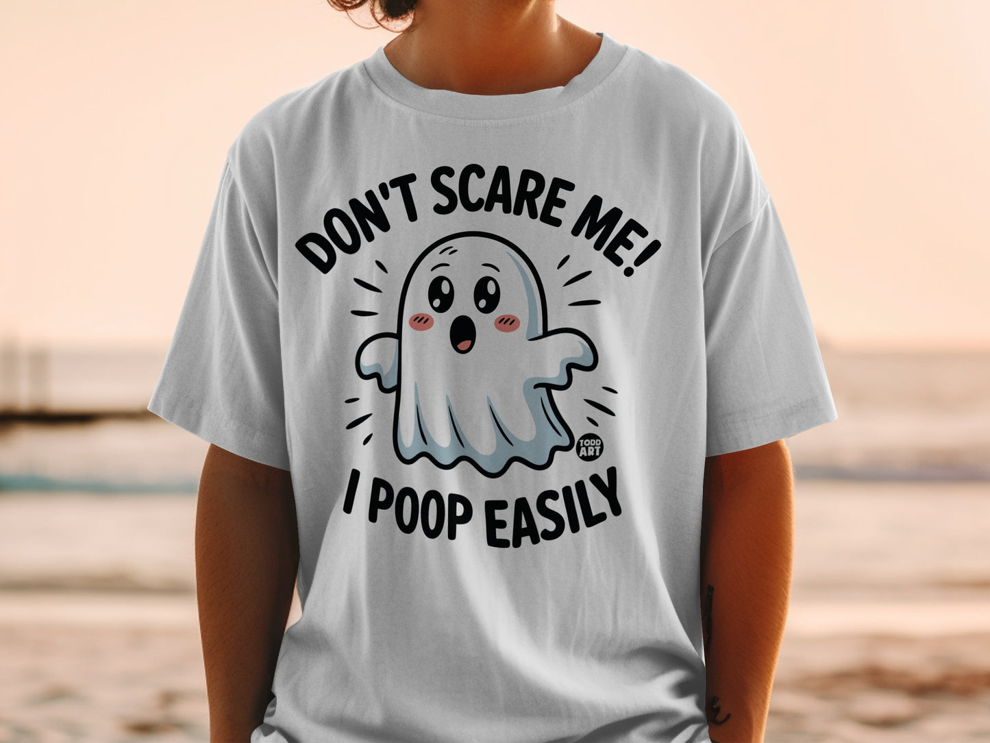 White t-shirt with a cartoon ghost saying "Don't Scare Me! I Poop Easily."
