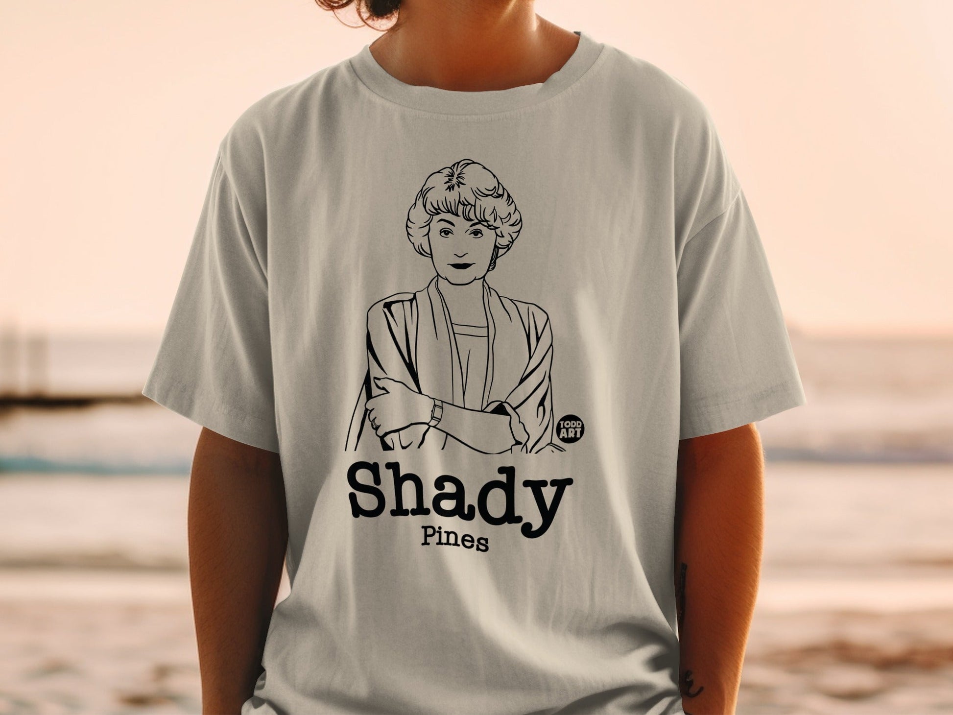 T-shirt featuring a line drawing of a woman and "Shady Pines" text.